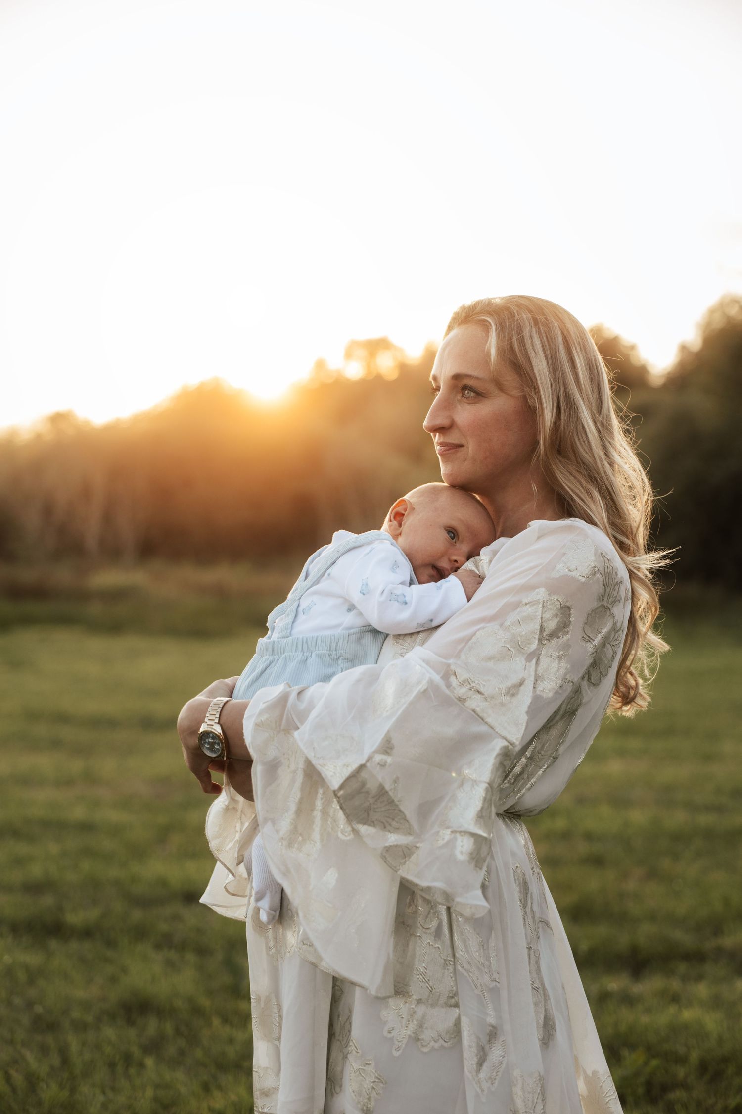 Joyful spinning dance in white dresses against a golden sunset in a grassy field.