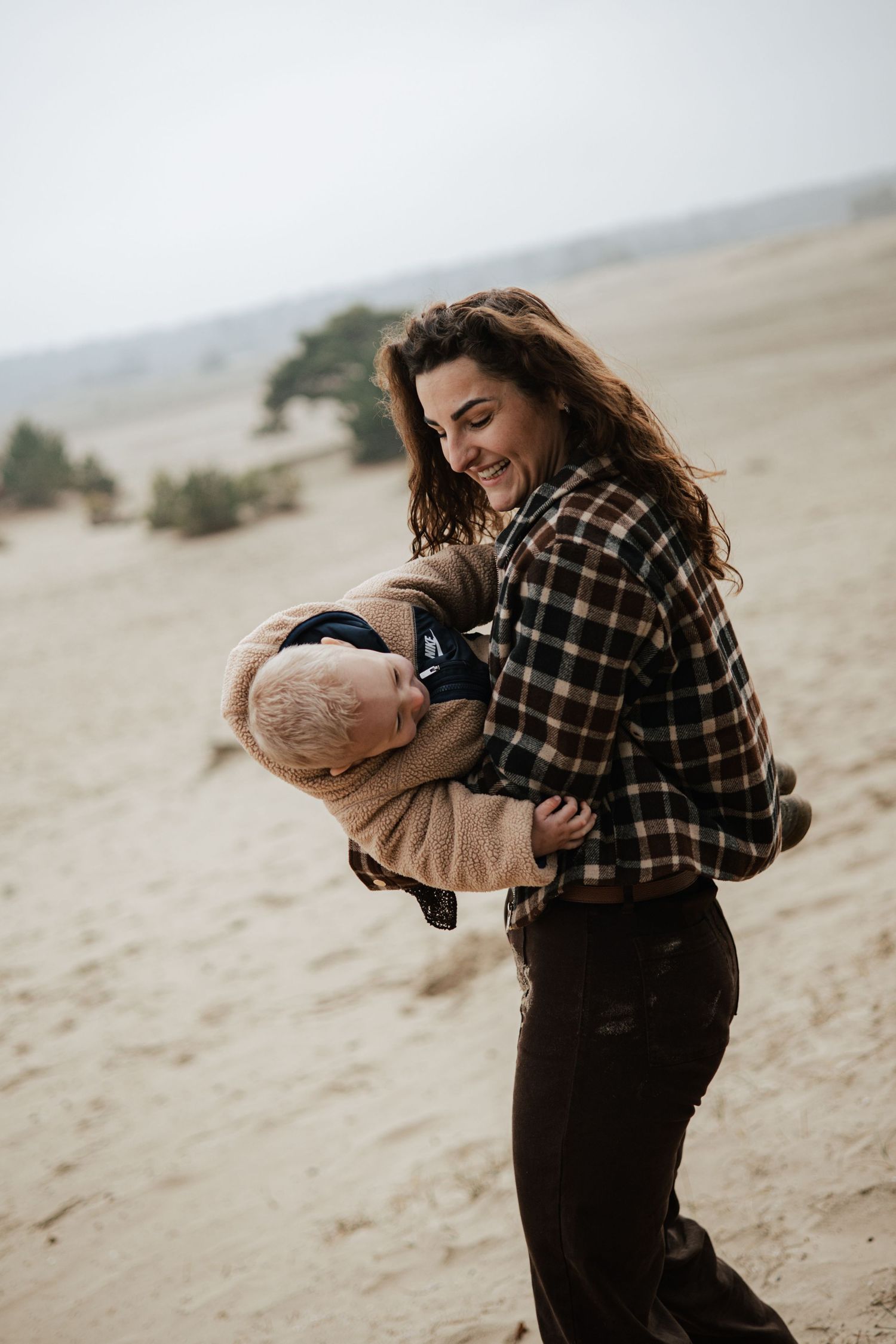 Playful sequence showing interaction between two people on a sandy desert landscape.