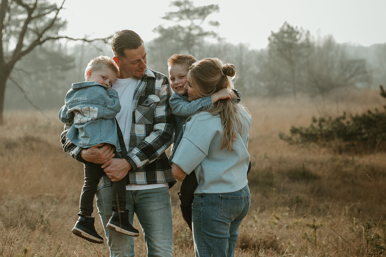 Candid family moment captured in rustic outdoor setting with soft lighting.