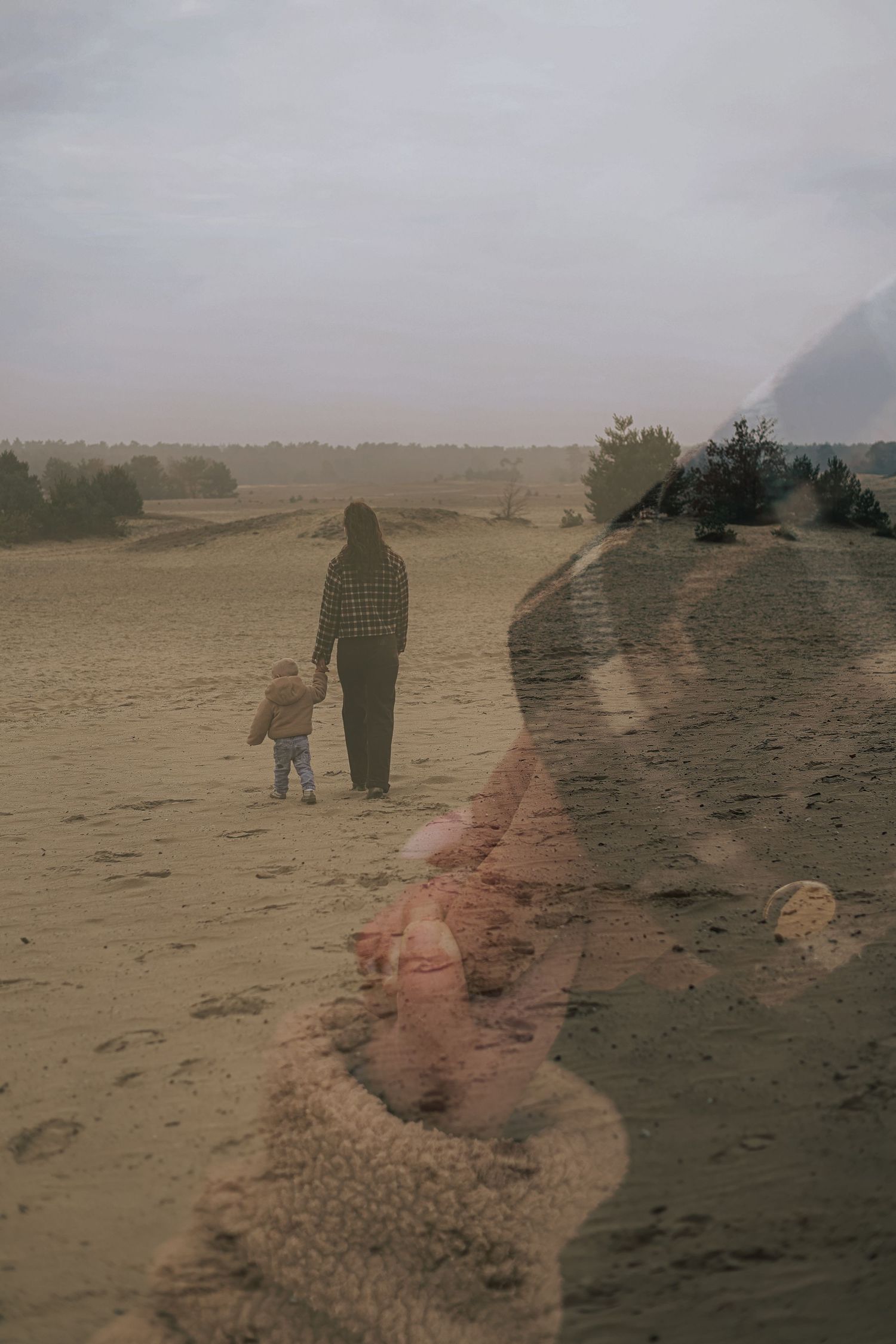 Misty sequence of figures walking along a beach path in overcast weather.