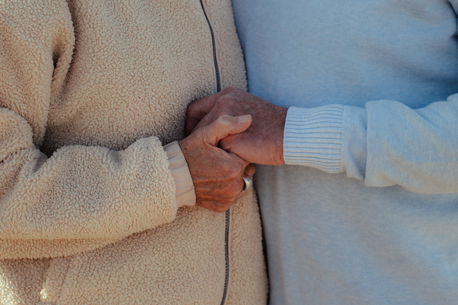 Close-up detail of cozy winter sweaters in soft neutral tones.