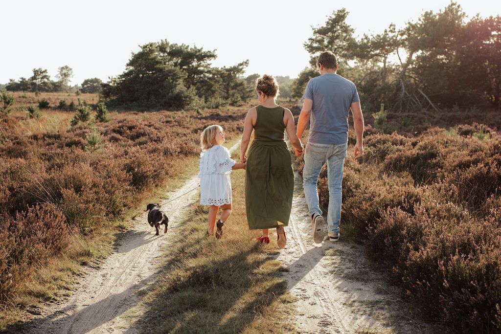 Family strolling along a scenic nature path during sunset.