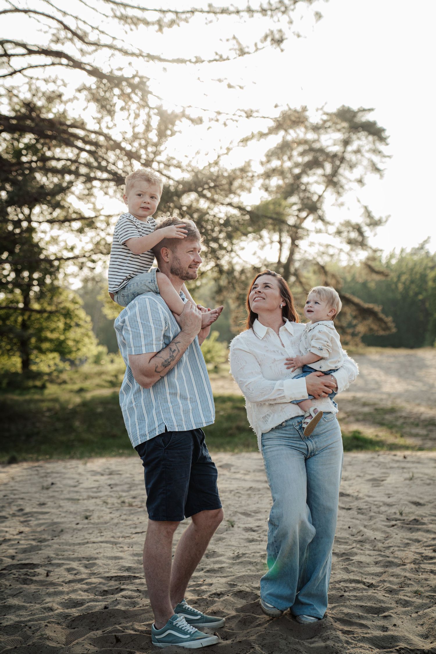 Happy family enjoying a sunset moment together at a beach or park setting.