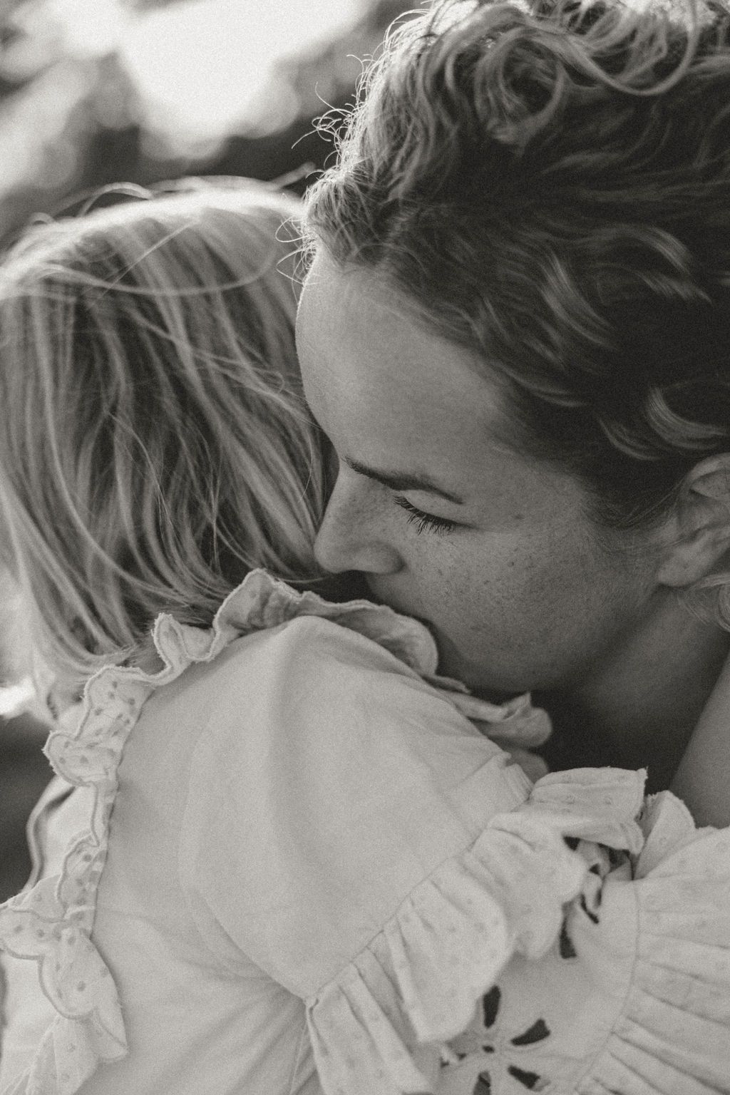 Intimate black and white portrait showing tender affection in soft lighting.