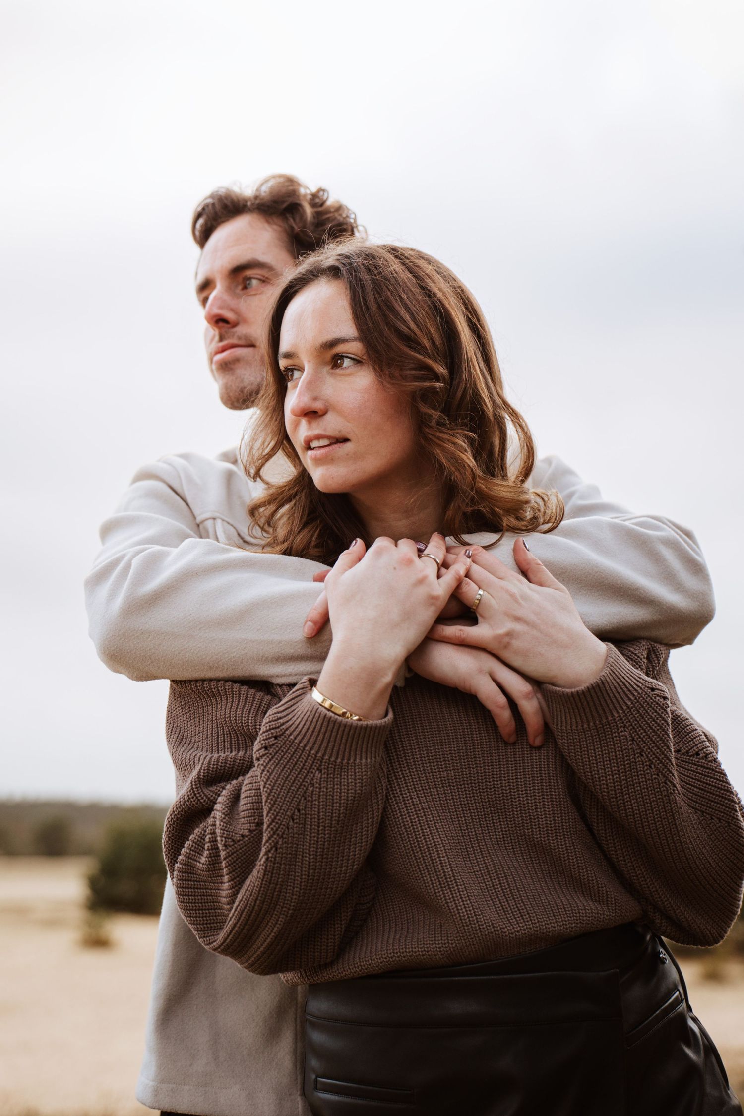 Romantic outdoor portrait of couple embracing in warm evening light.