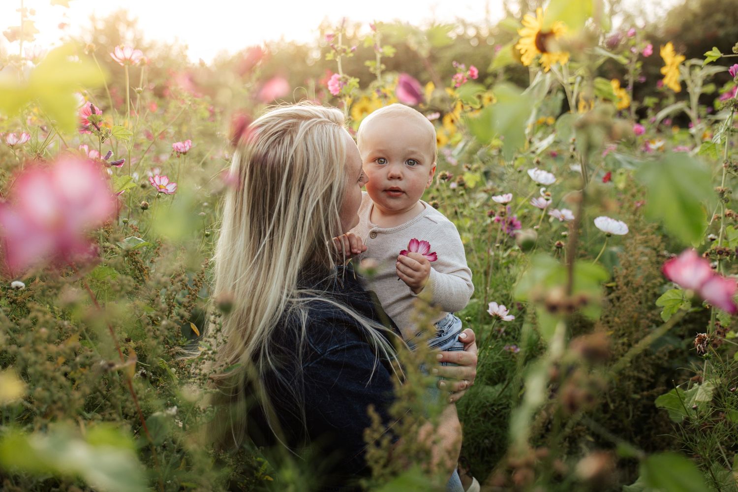 Sweet moments captured in a wildflower field during golden hour family photography session.