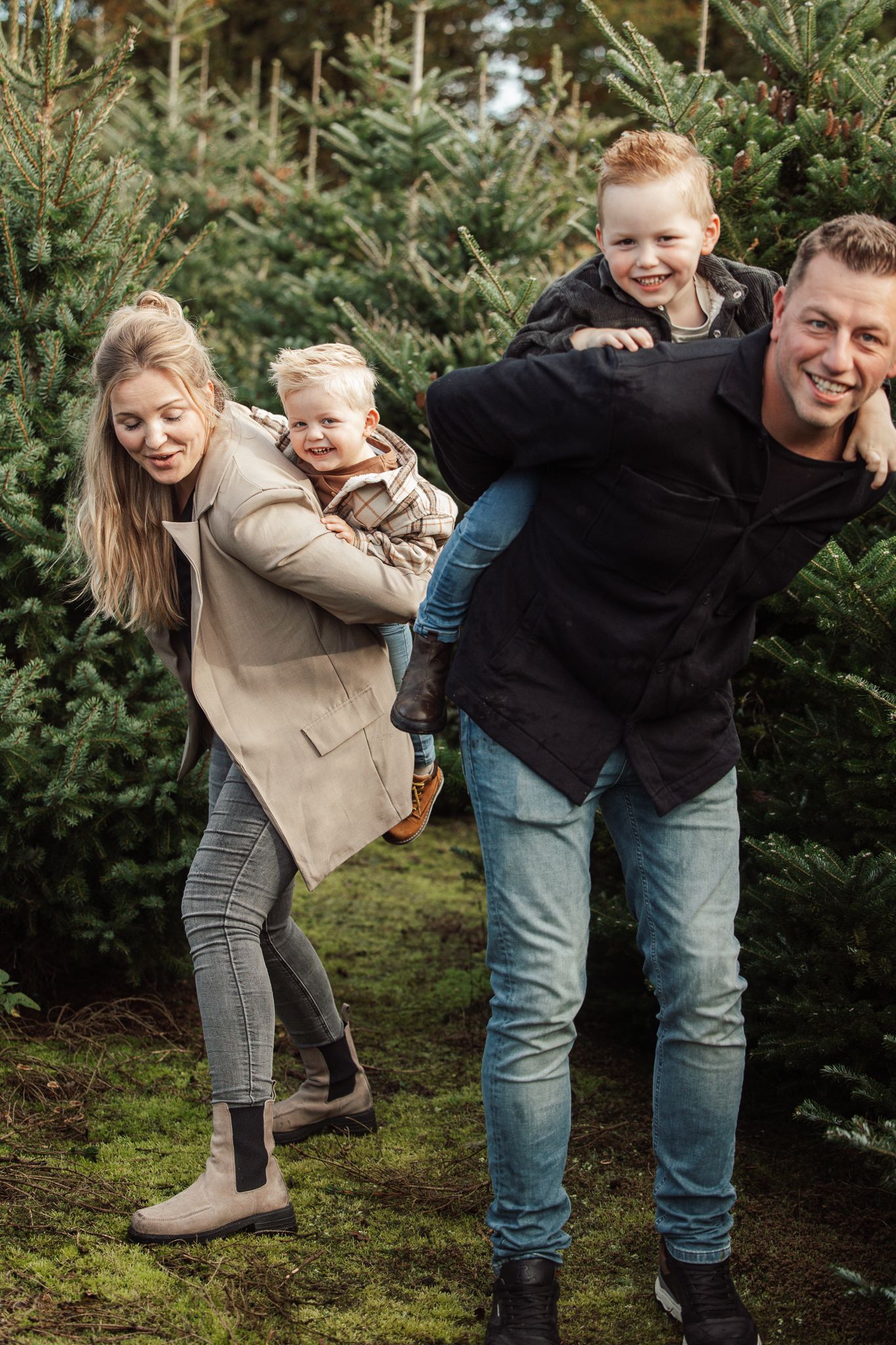 Playful family photos showing genuine laughter and joy among pine trees.