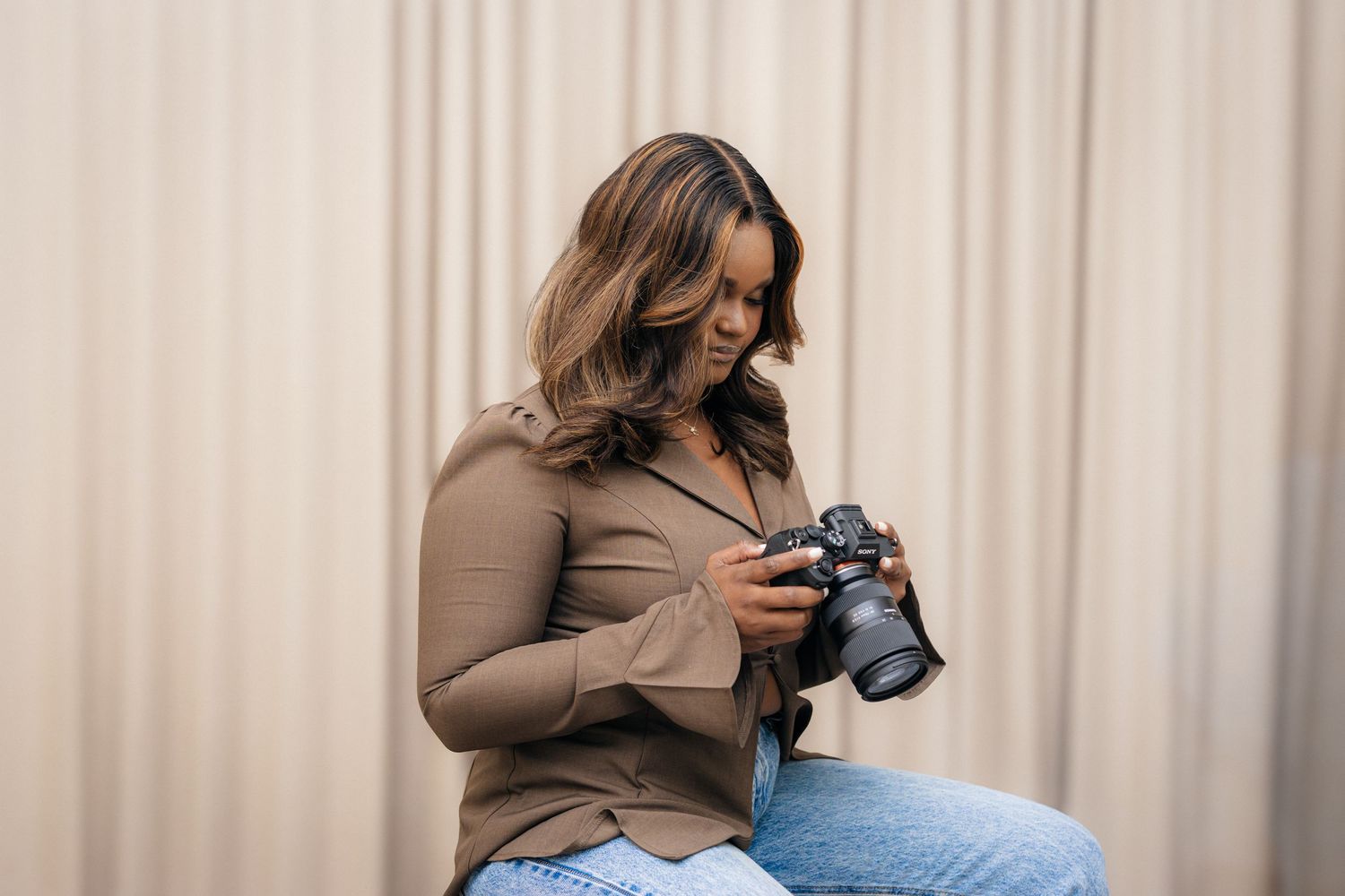 Stylish casual outfit featuring a taupe button-down shirt and relaxed denim in studio lighting.