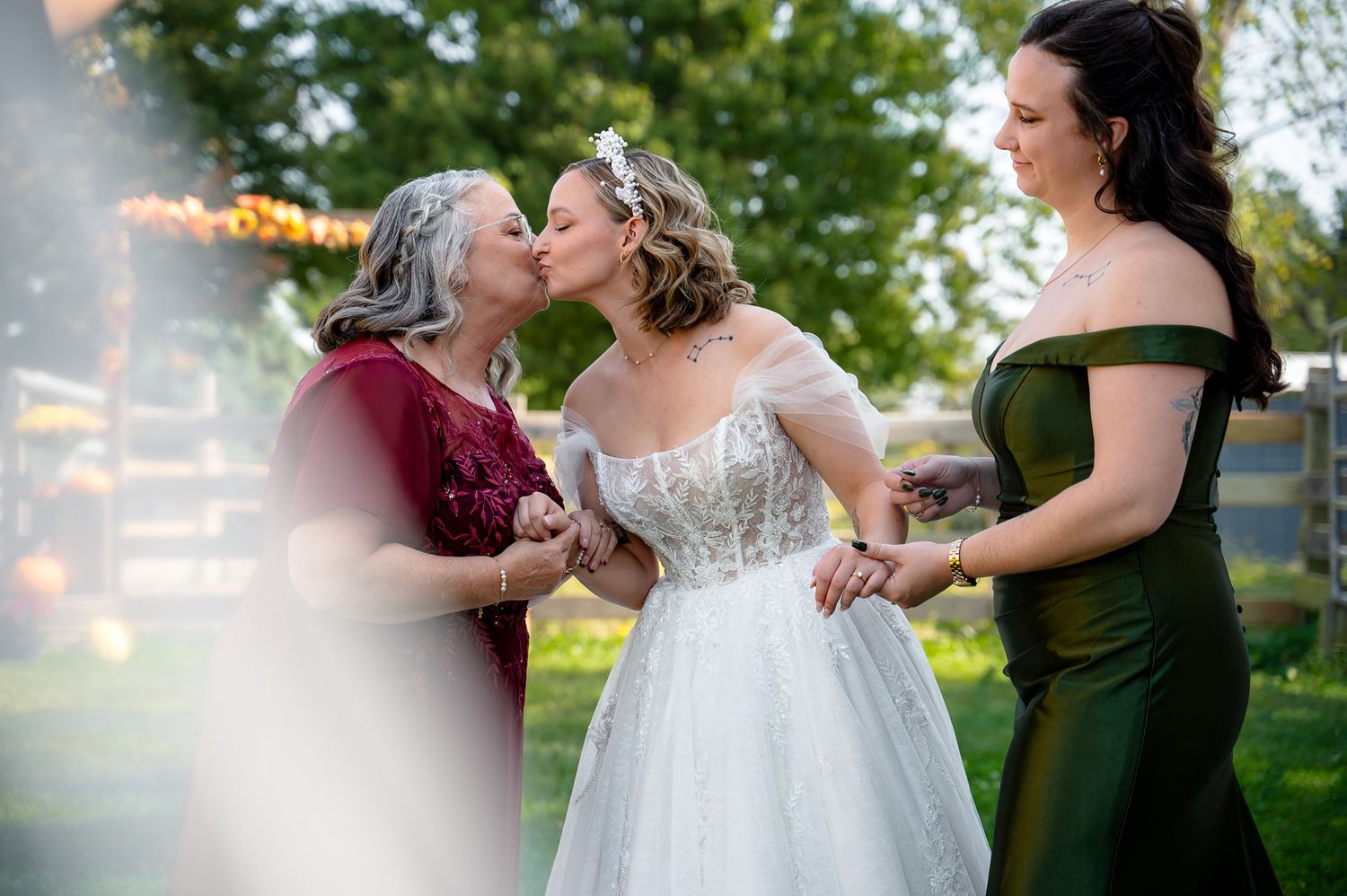 A wedding couple and their party share joyful moments together outdoors during a summer celebration.