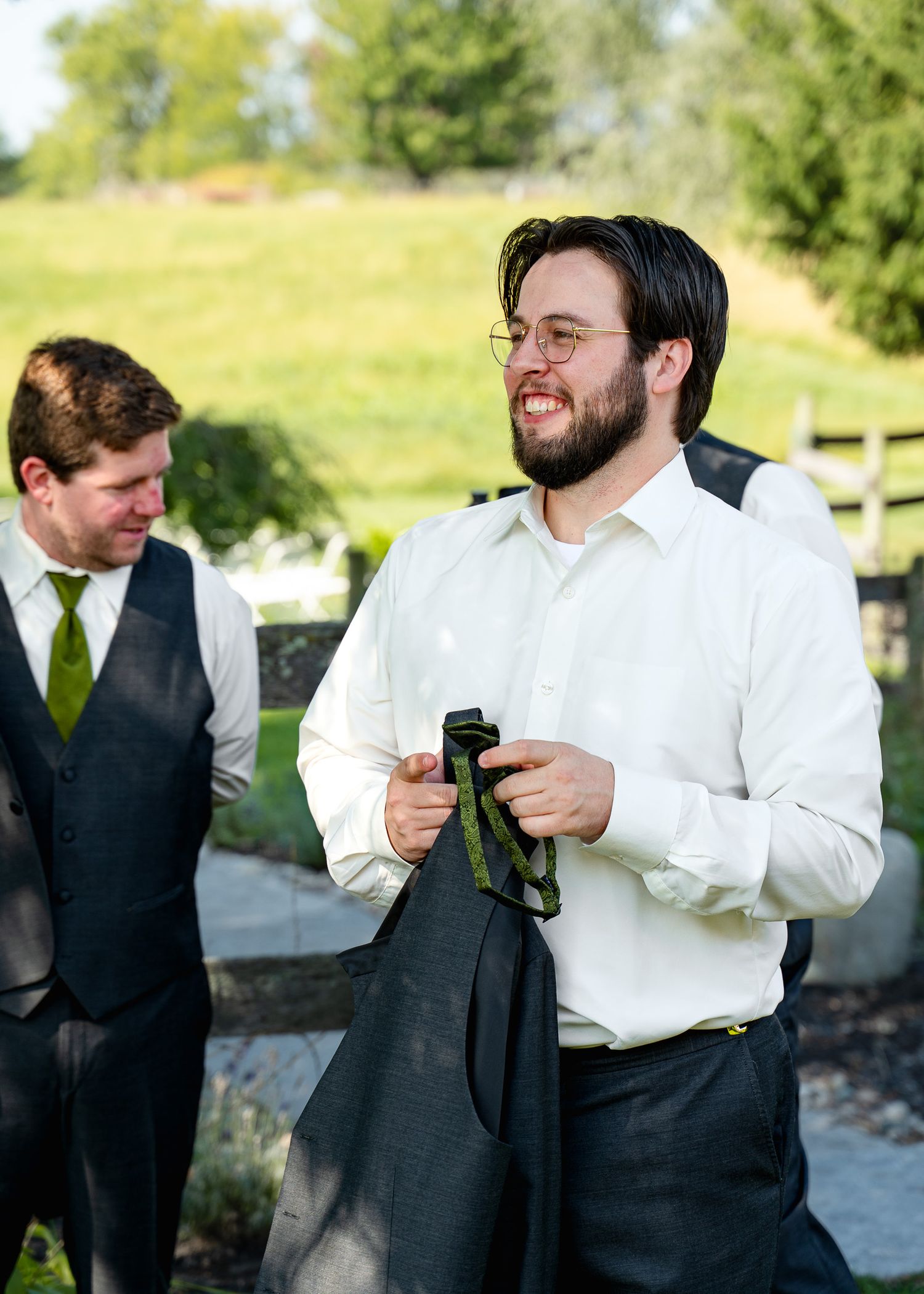 Groomsmen in formal attire share a lighthearted moment before the wedding ceremony.