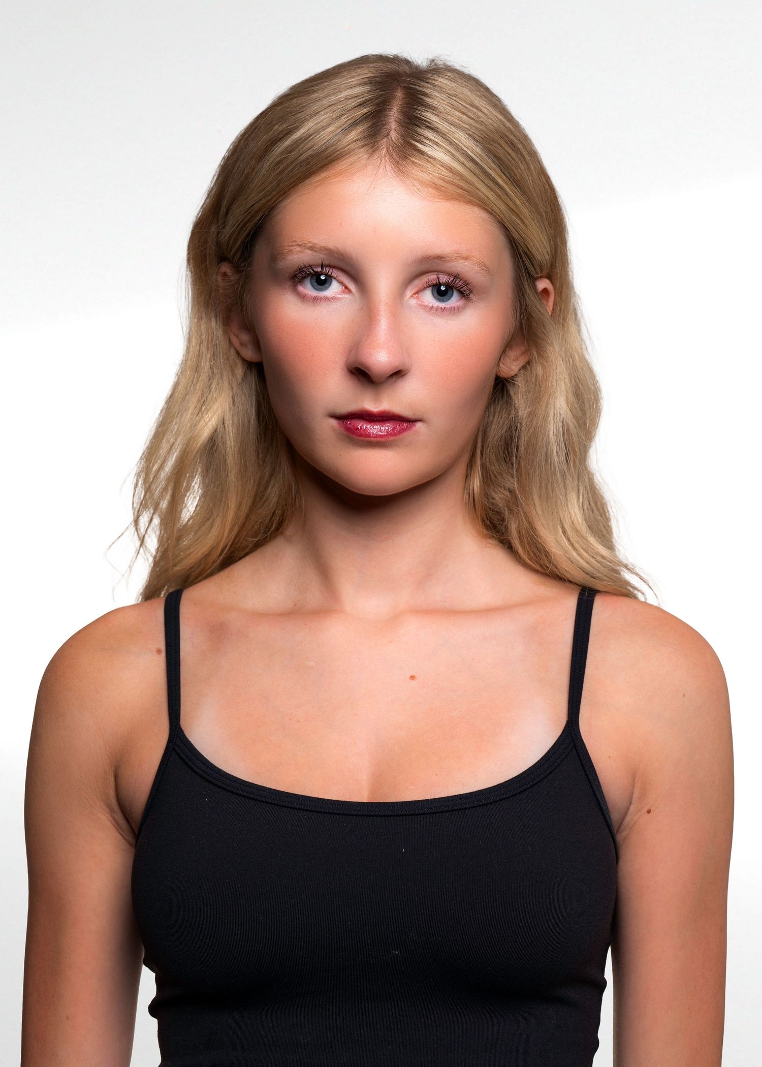 Portrait series in a black tank top against a white studio background.