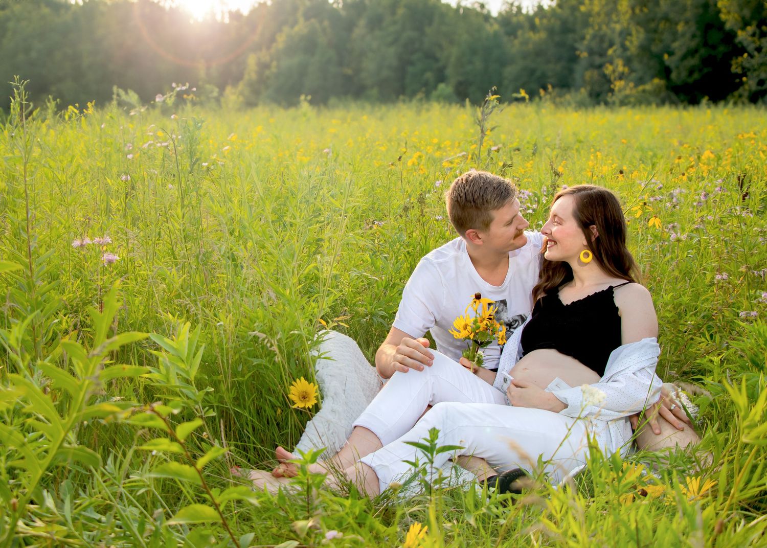 Romantic couple photo session in a field of yellow wildflowers at sunset.