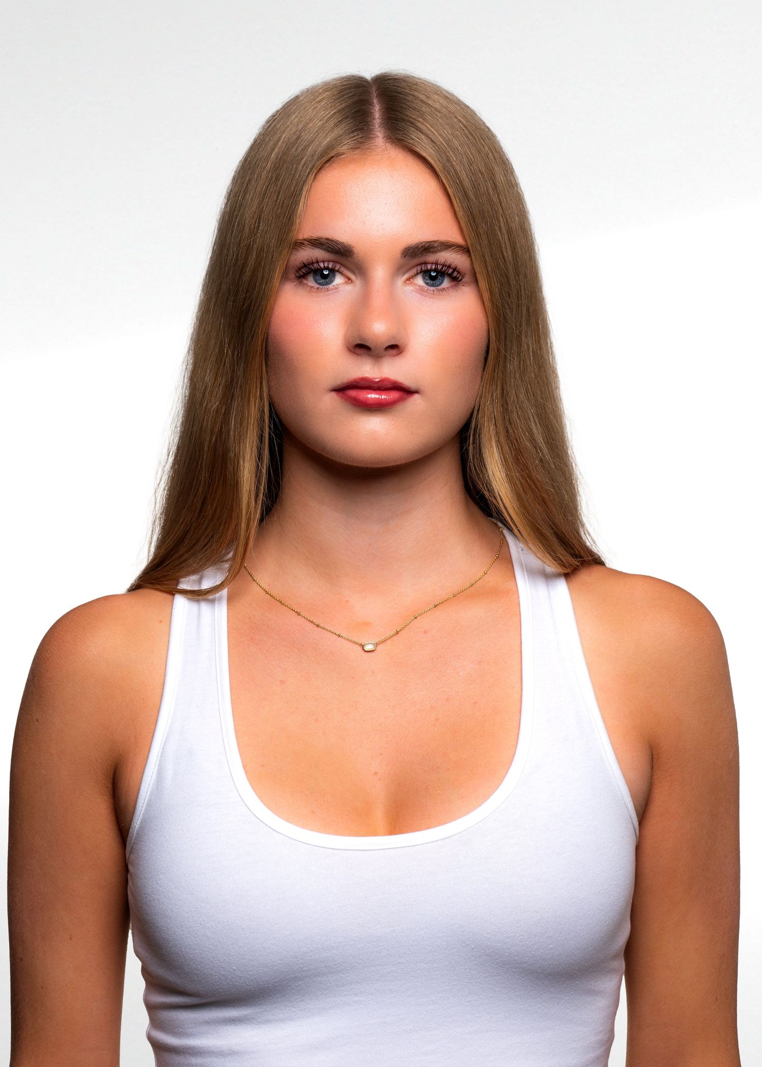 Studio portraits in a white tank top against a bright background.