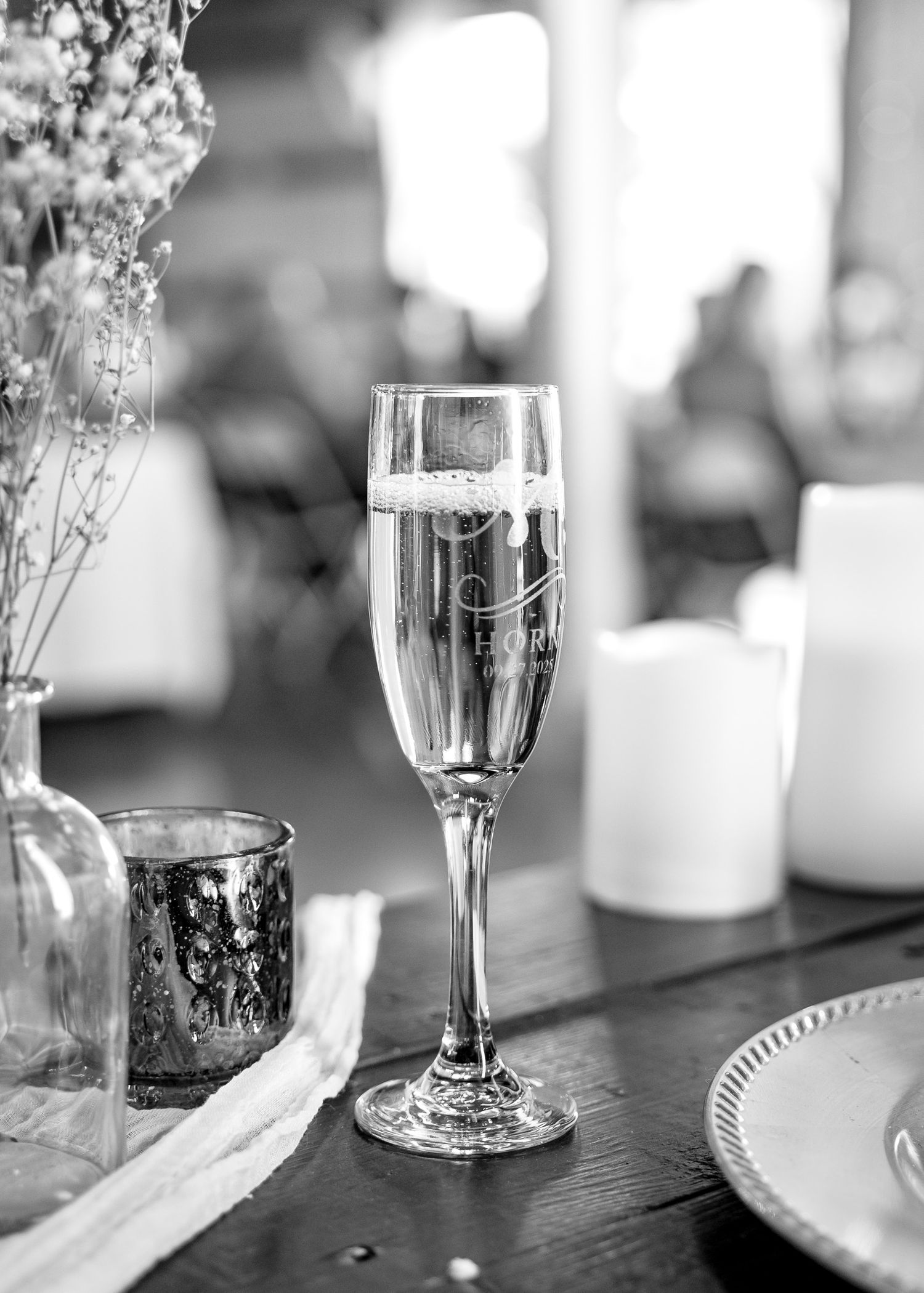 Elegant champagne flutes and glassware arranged on a dark wooden table.