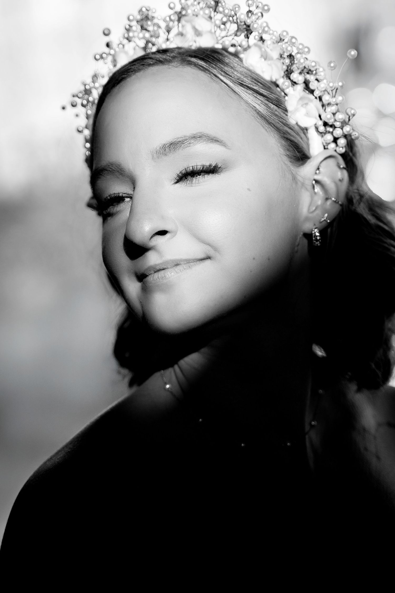 Ethereal black and white close-up portraits with delicate floral hair accessories in soft focus.