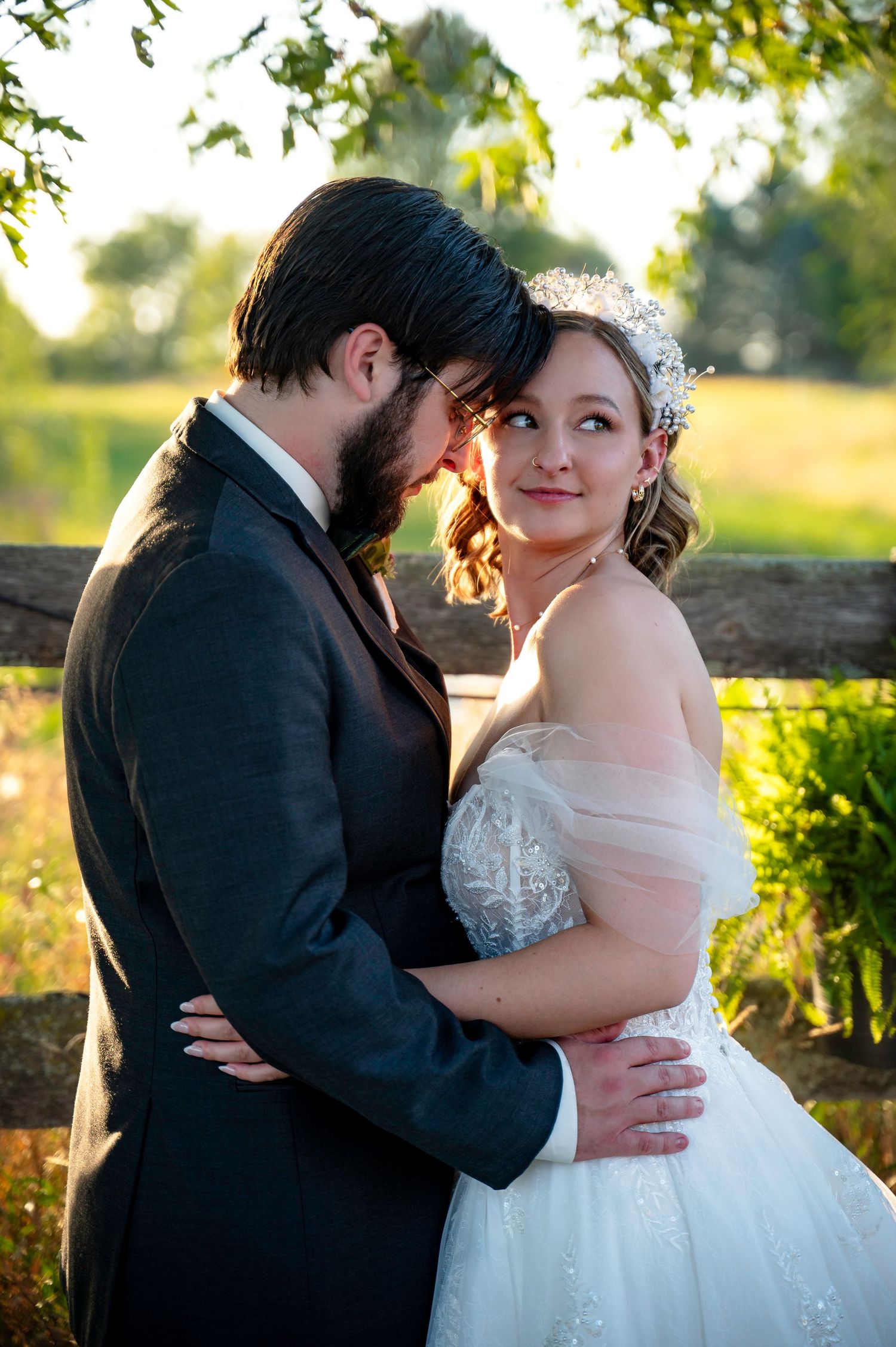 Romantic wedding couple shares intimate moments in golden sunlight against a natural outdoor backdrop.