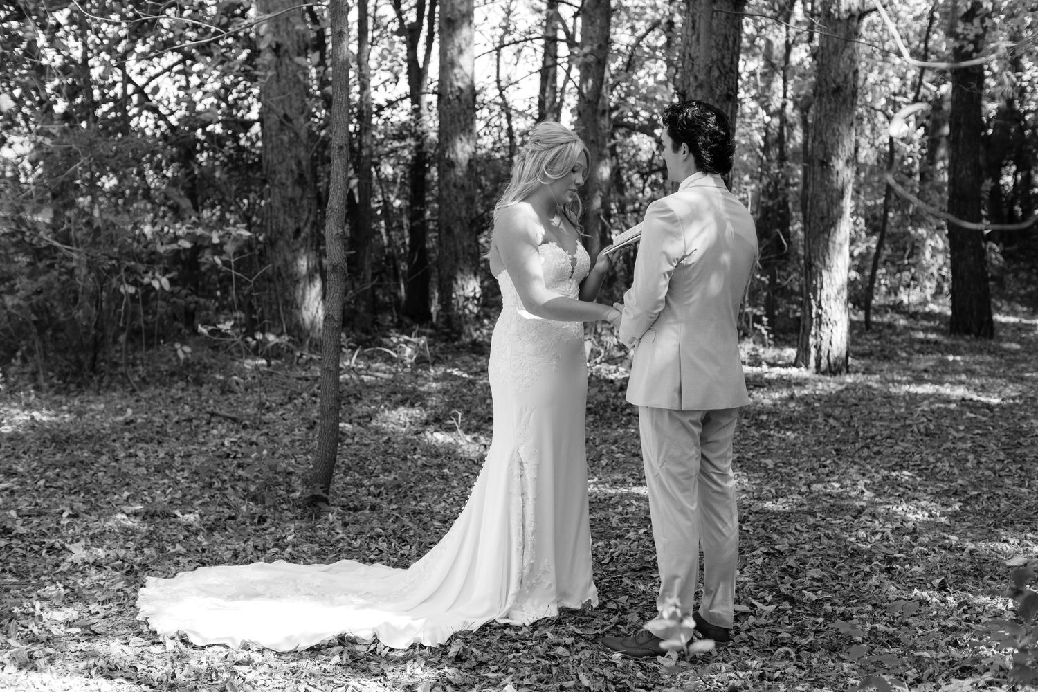 Black and white series of a couple's first look photos in a forest setting.