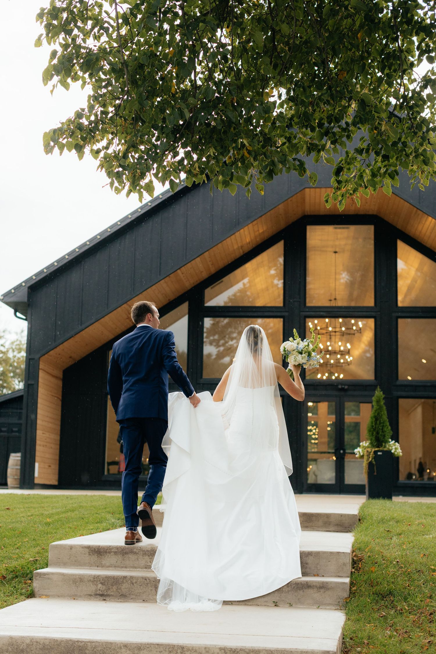 Modern black barn wedding venue with wooden accents and string lights.