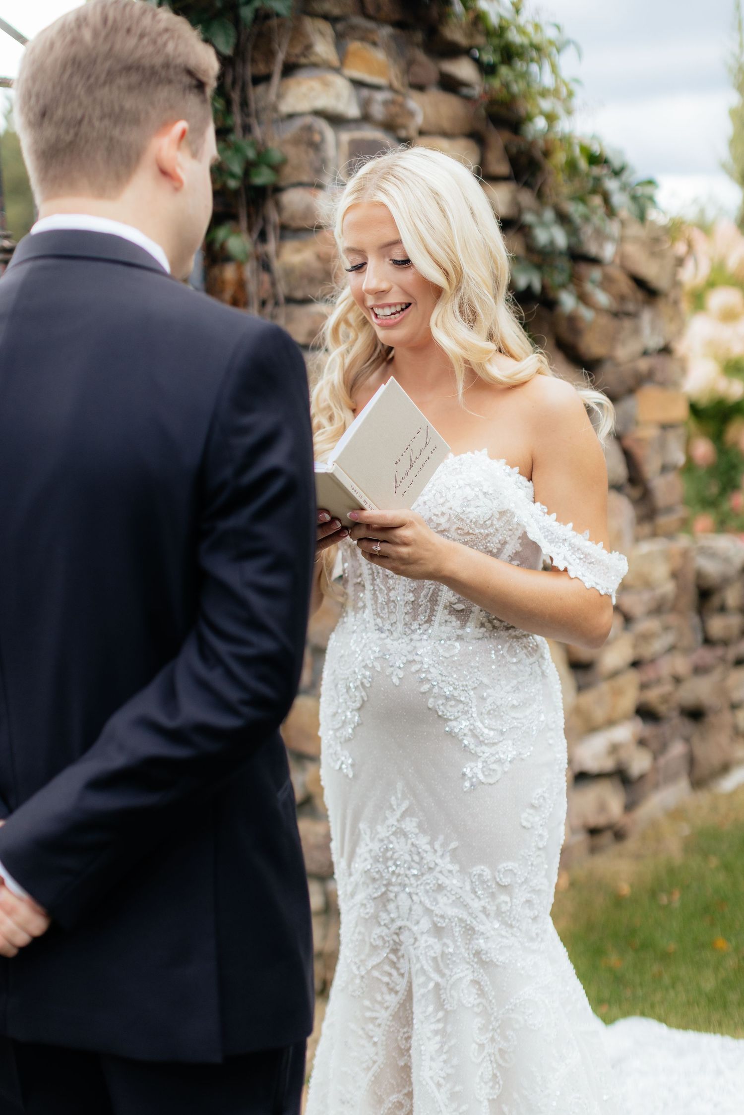 A couple shares emotional vows during their outdoor garden wedding ceremony.