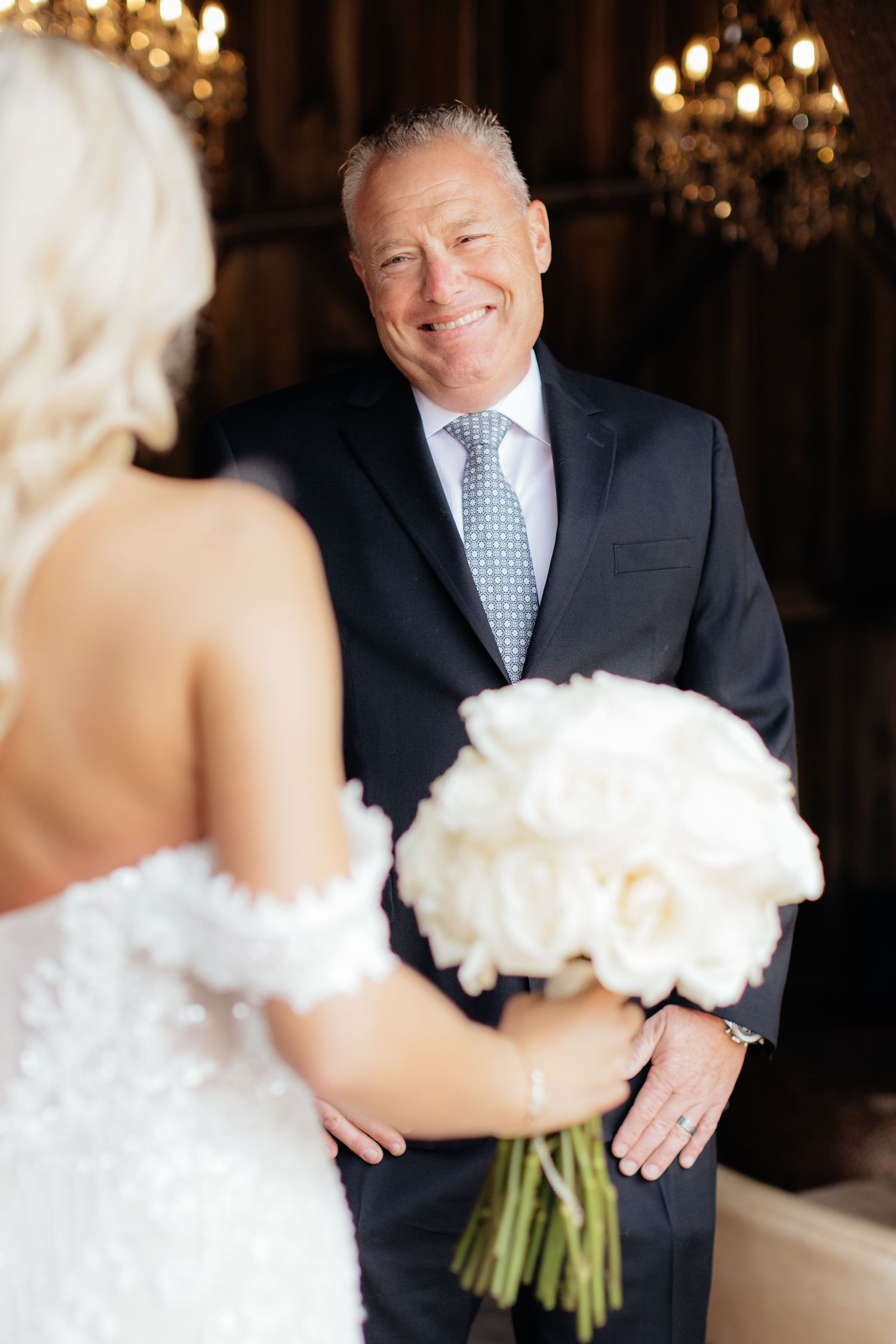 Indoor wedding photos with warm lighting and white floral bouquet.