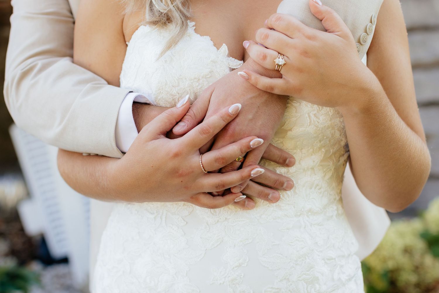 Close-up details of wedding rings and hands during an intimate moment.