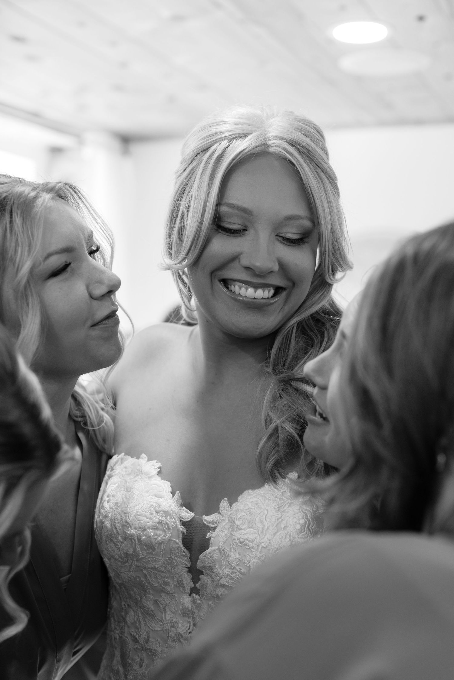 Black and white candid moment of bride getting ready on wedding day.