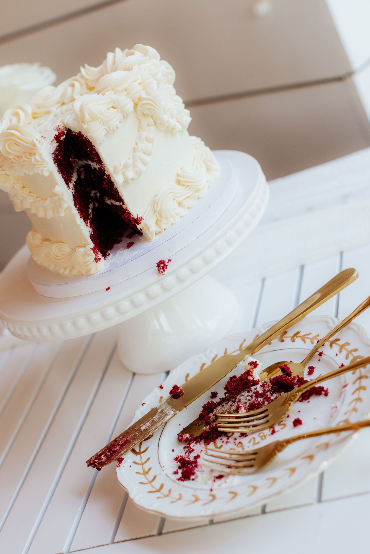 Sequence of images showing a partially eaten white wedding cake with red filling on an ornate plate.