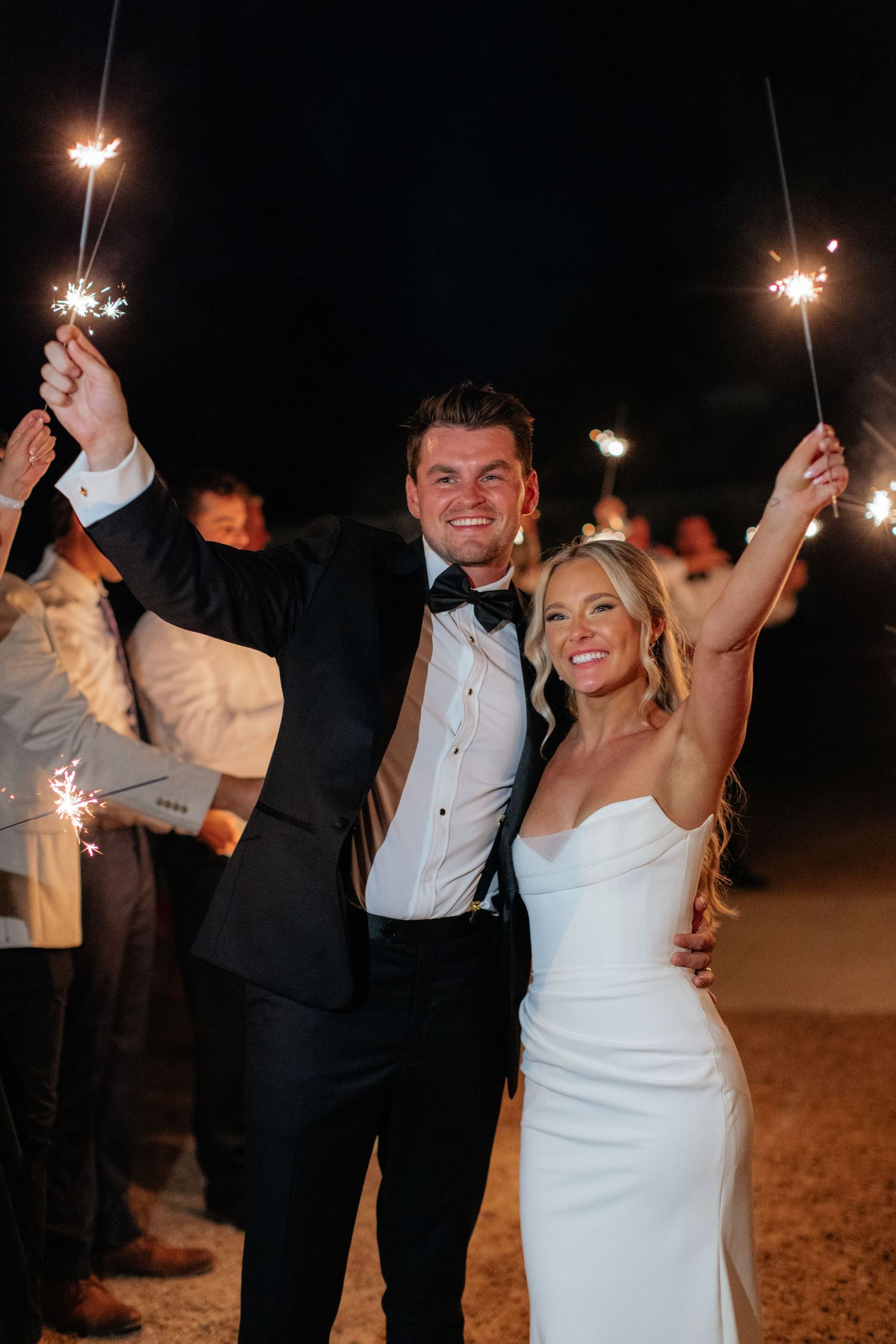 Wedding couple celebrates with sparklers during their evening reception dance.