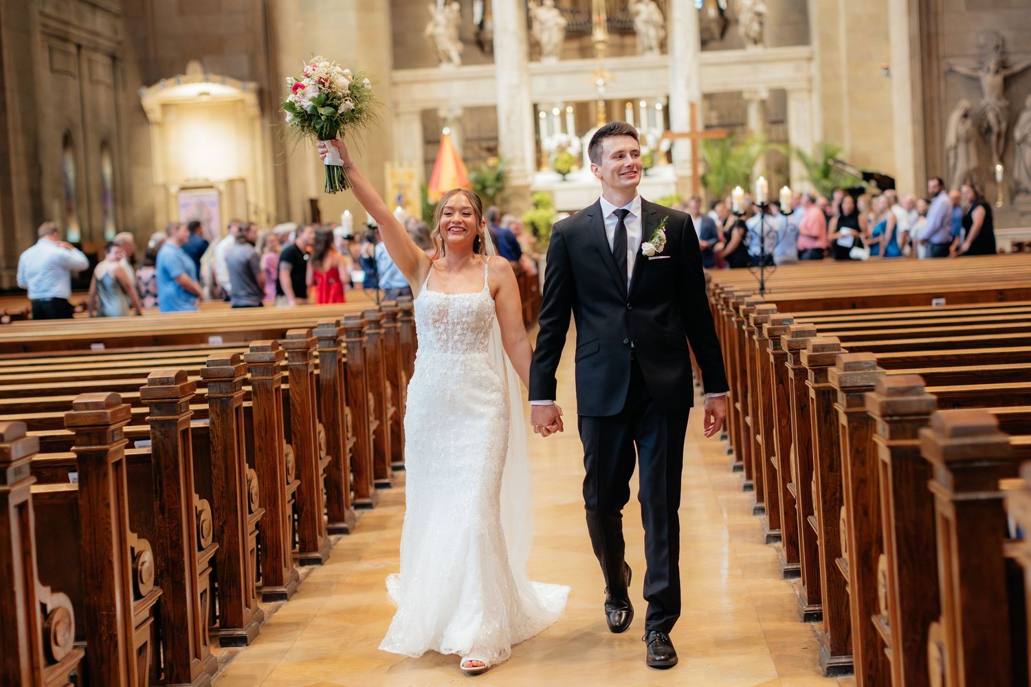 Traditional church interior with wooden pews and elegant architecture during a wedding ceremony.