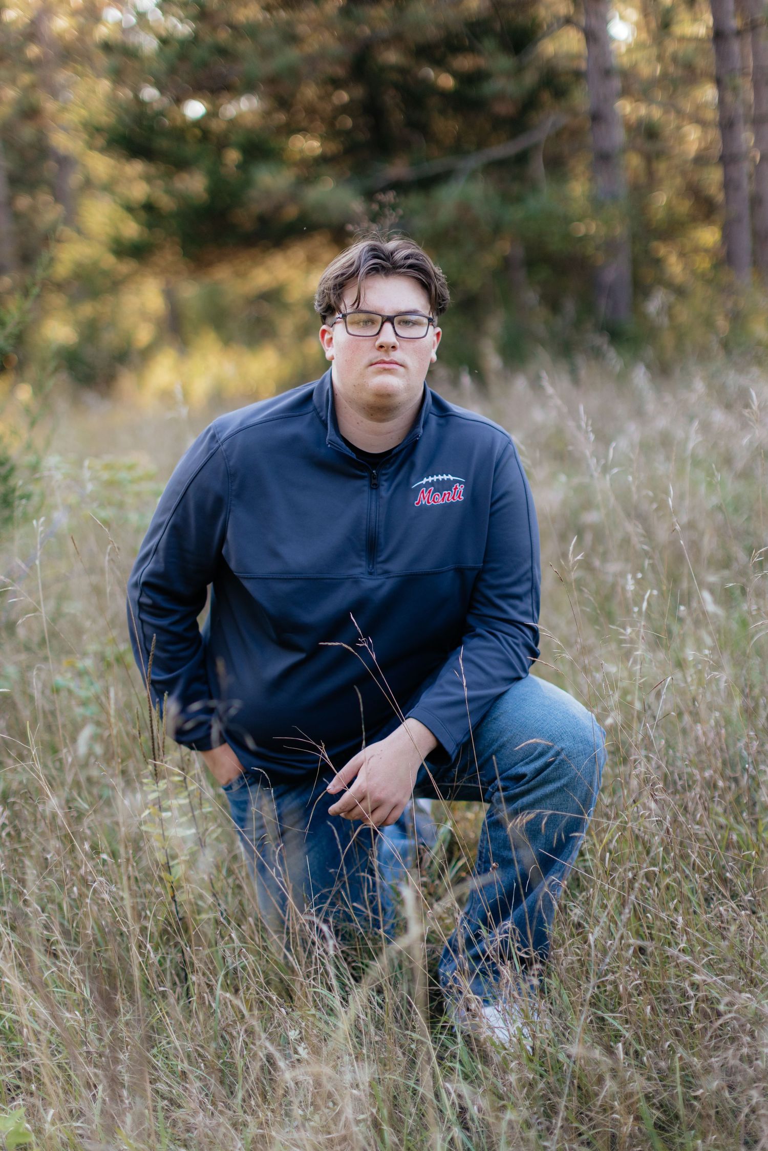 A navy blue jacket and jeans ensemble is photographed in a field of tall grass.
