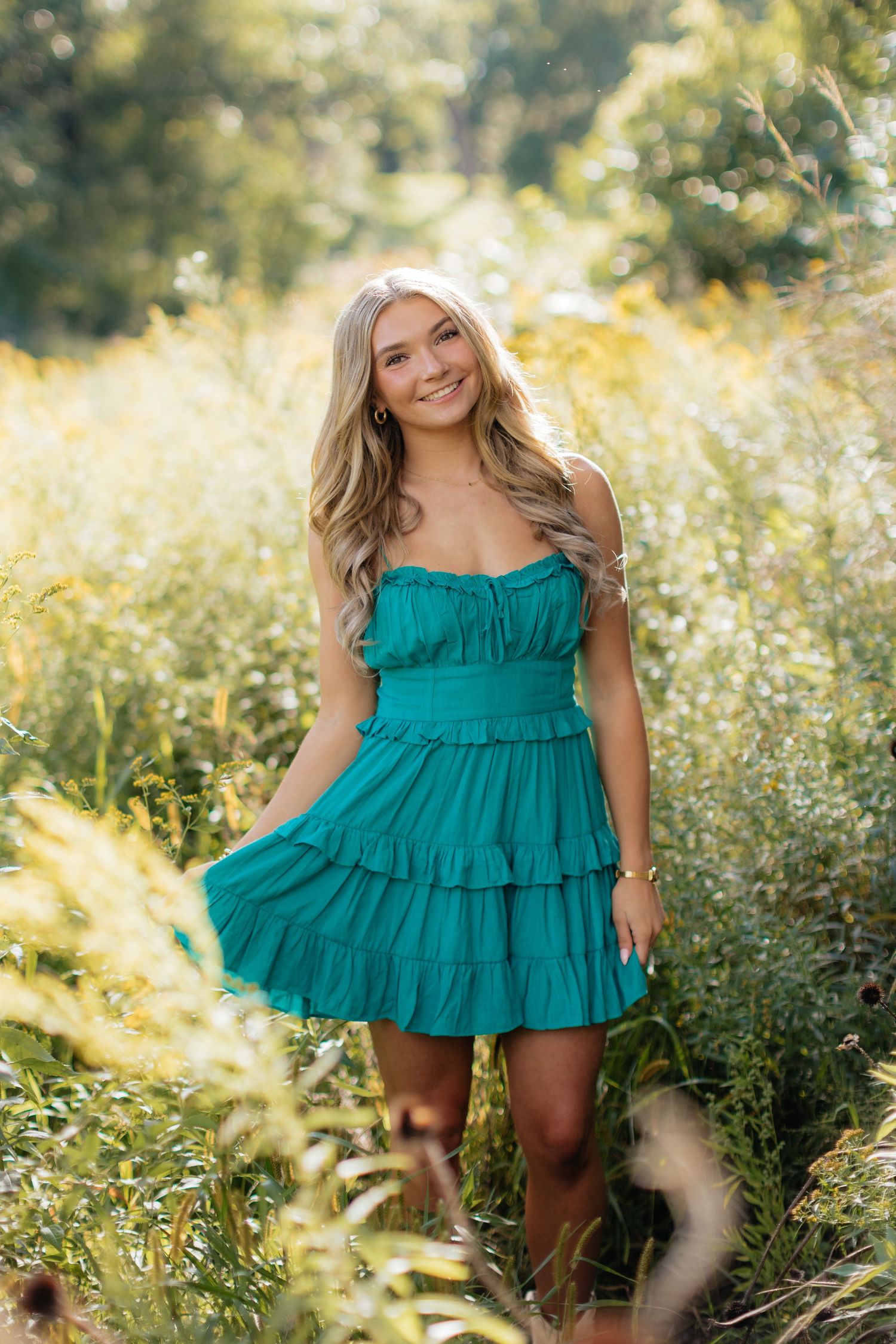 Summer portrait session in teal ruffle dress among wildflowers.