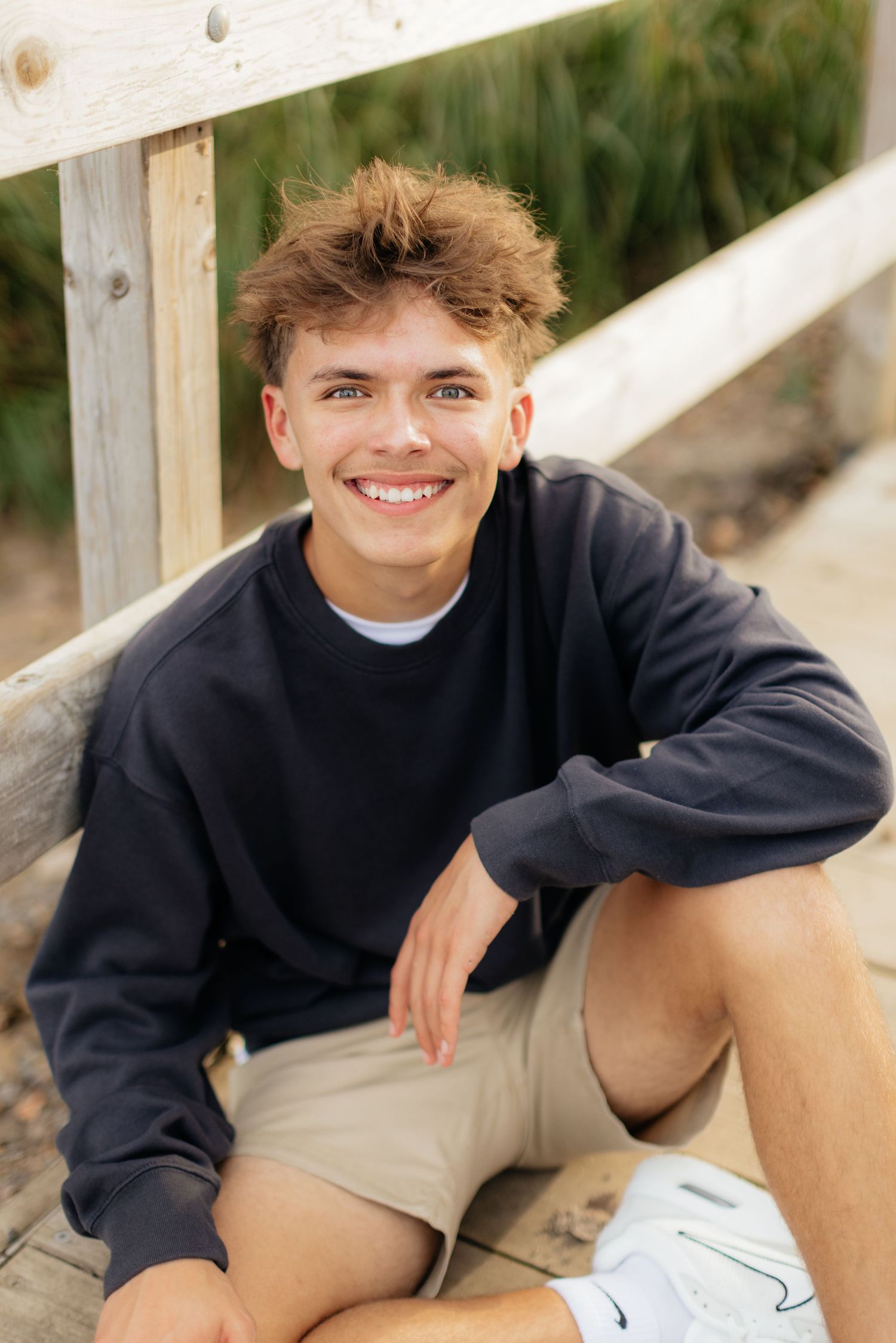 A casual outfit featuring a navy sweater and khaki shorts is worn outdoors.