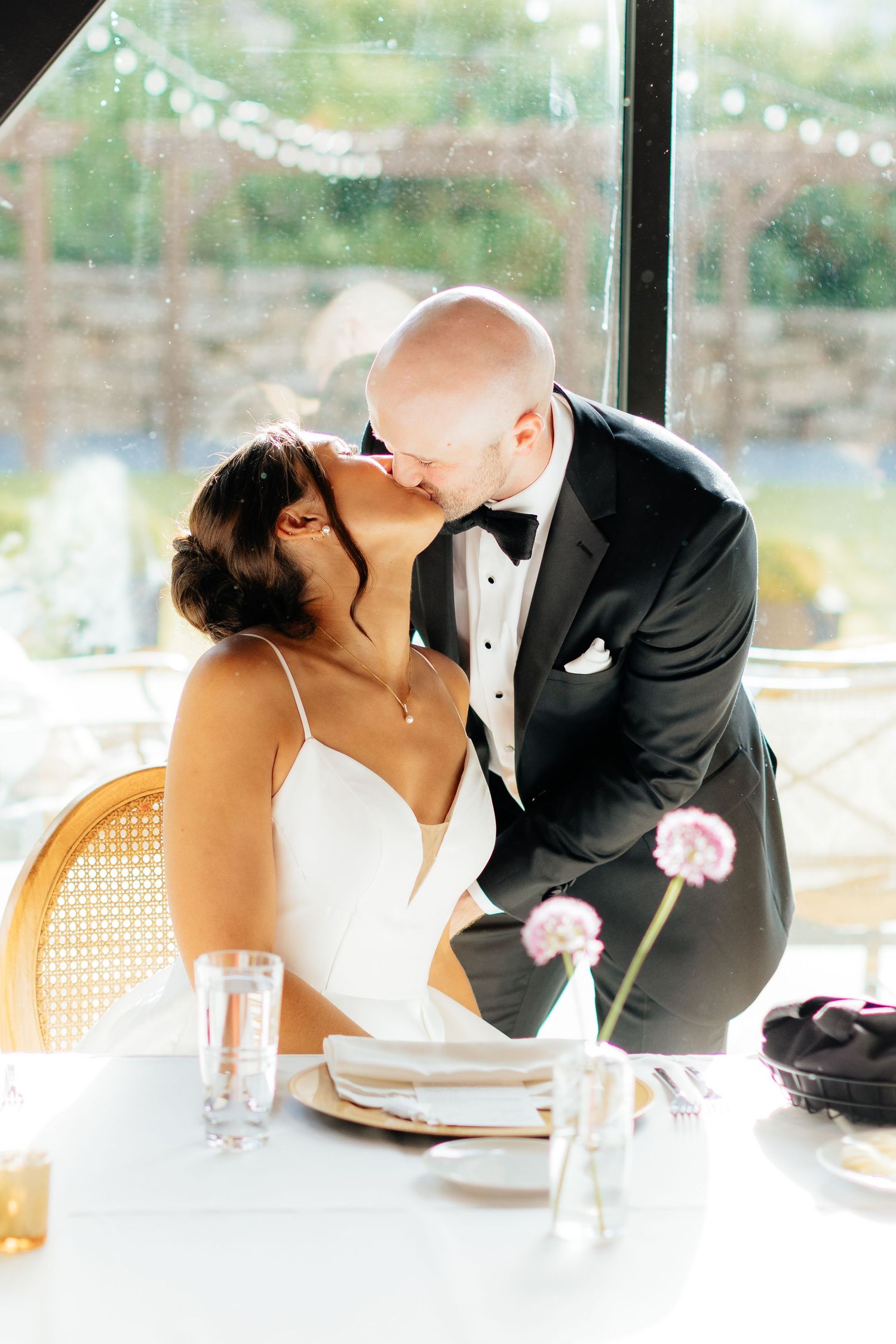Romantic wedding couple shares intimate moments at a dining table.