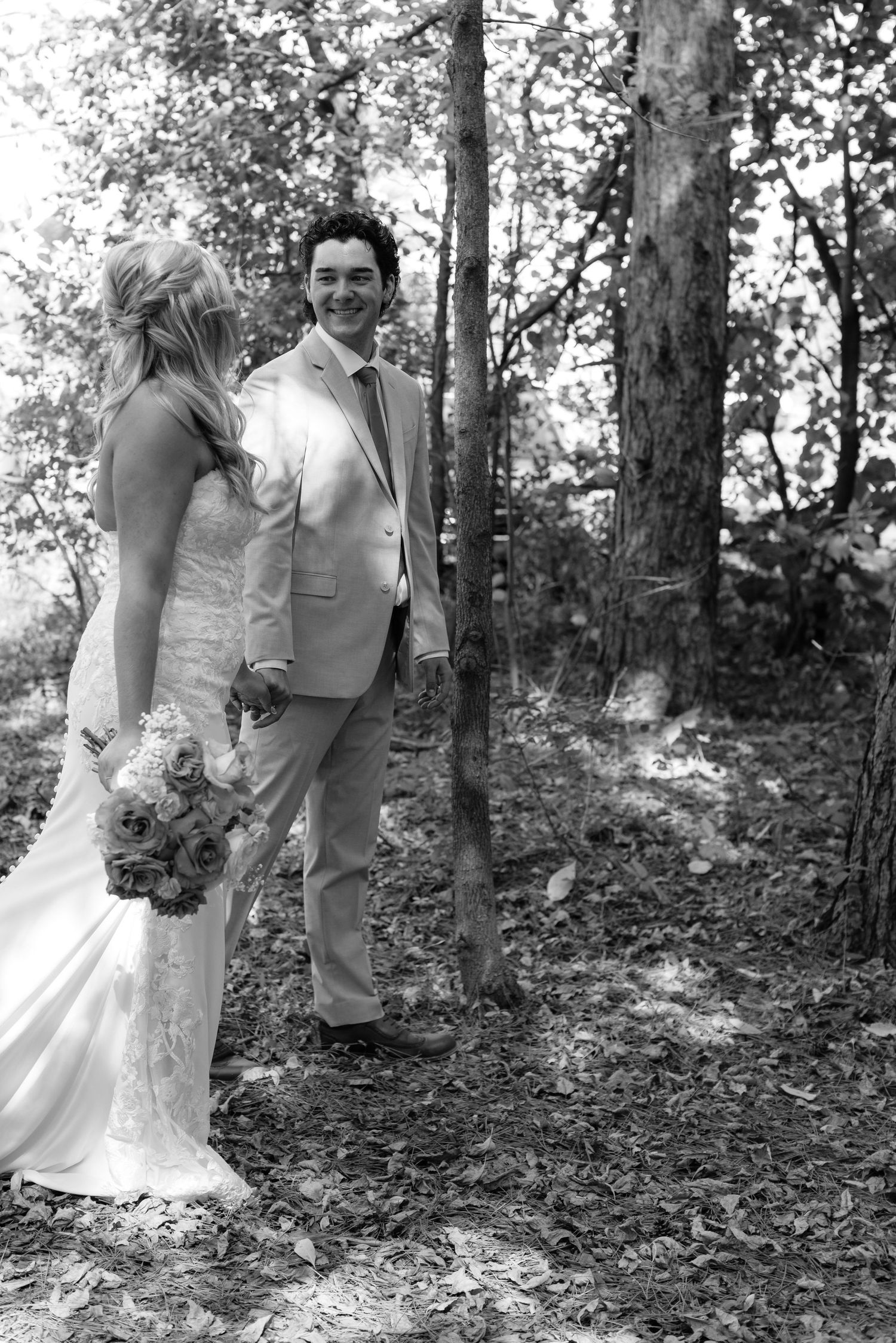 Black and white series showing tender moments between newlyweds in forest setting.