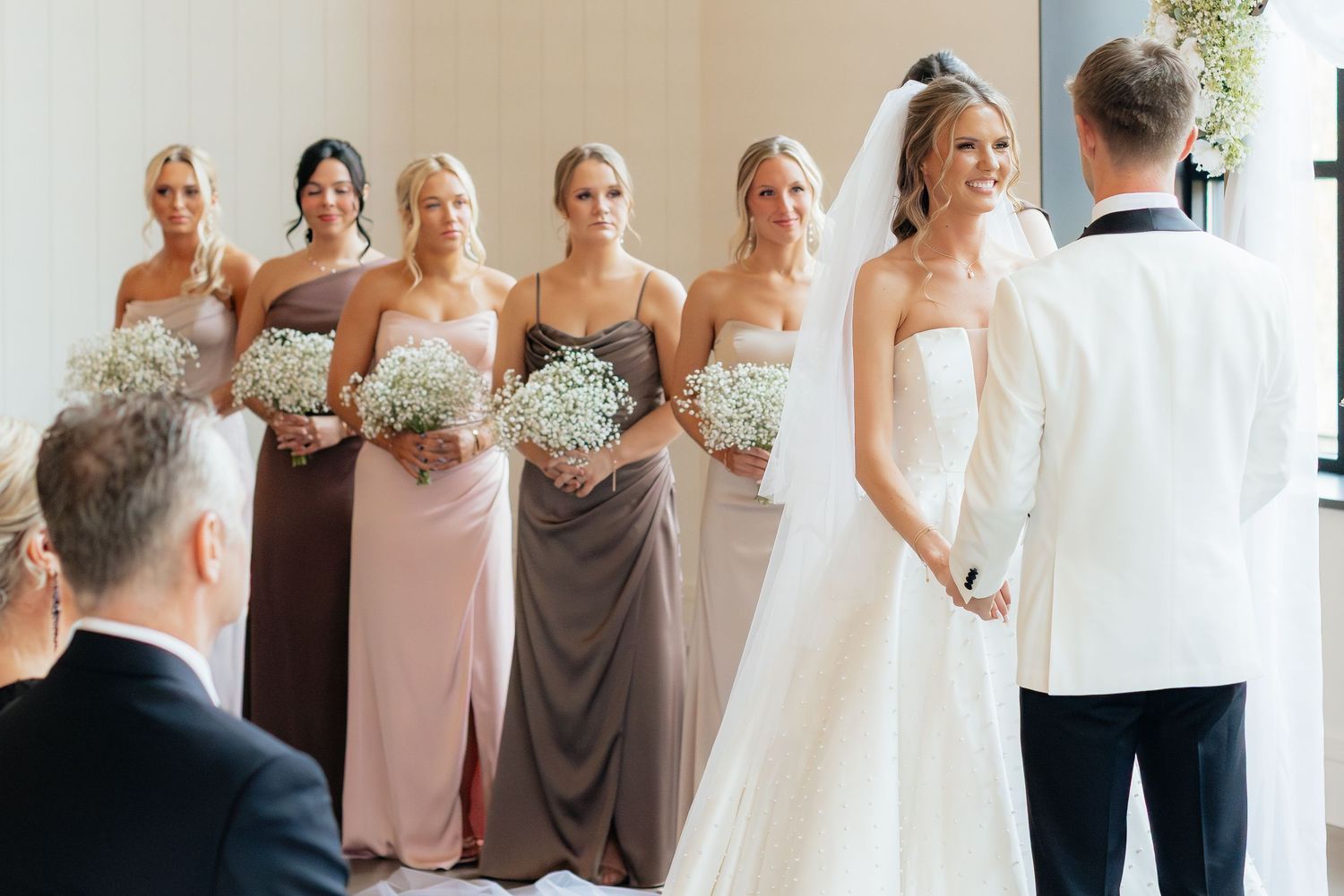 Wedding party in pastel dresses poses together for group photos.