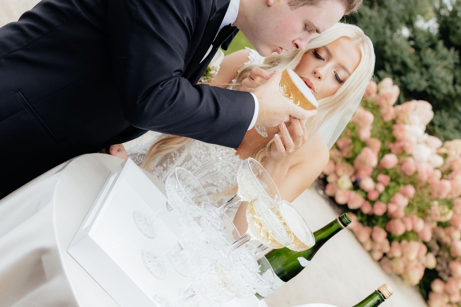 Champagne being poured during an elegant outdoor wedding celebration.