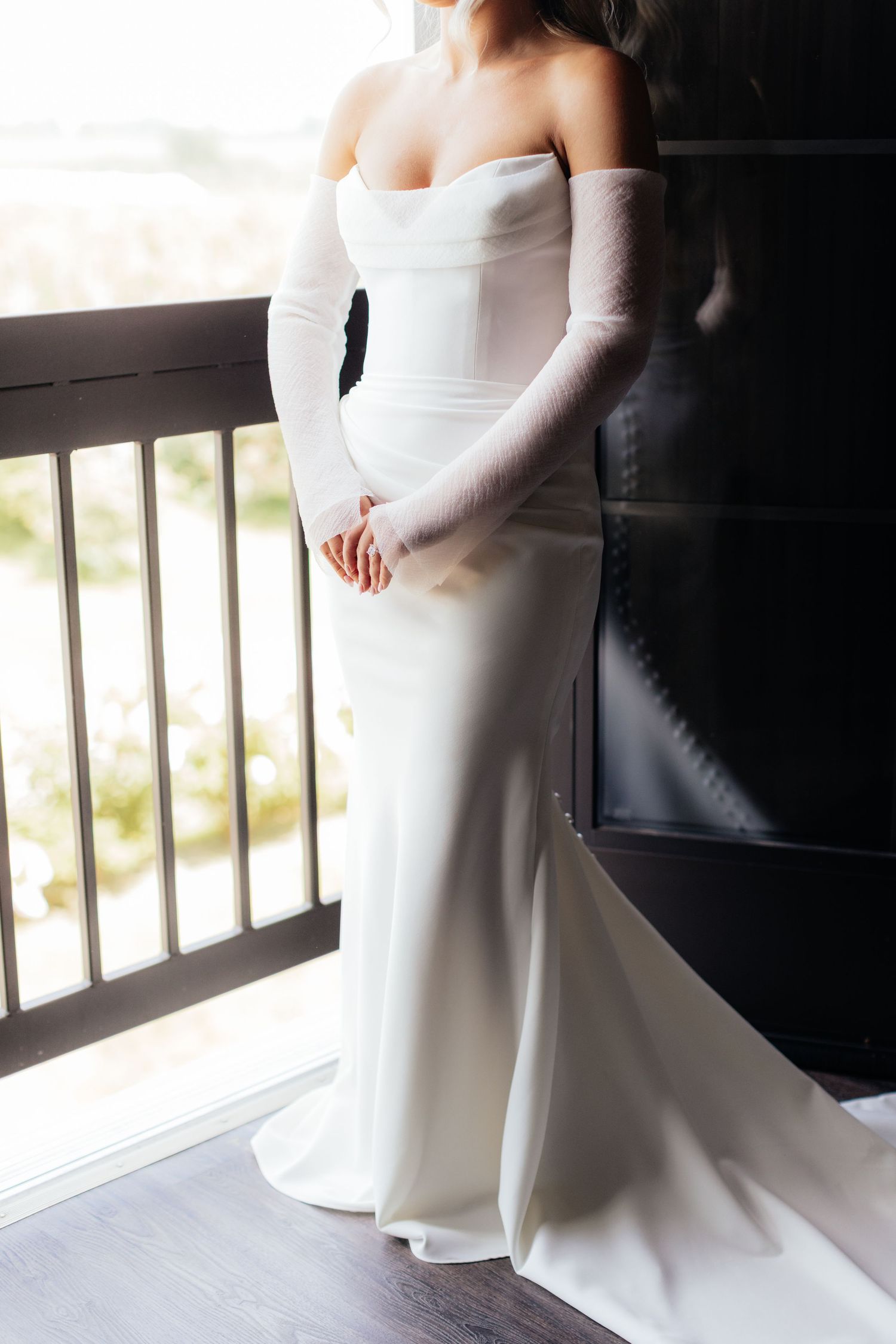 Elegant fitted white wedding dress with off-shoulder design and long sleeves.