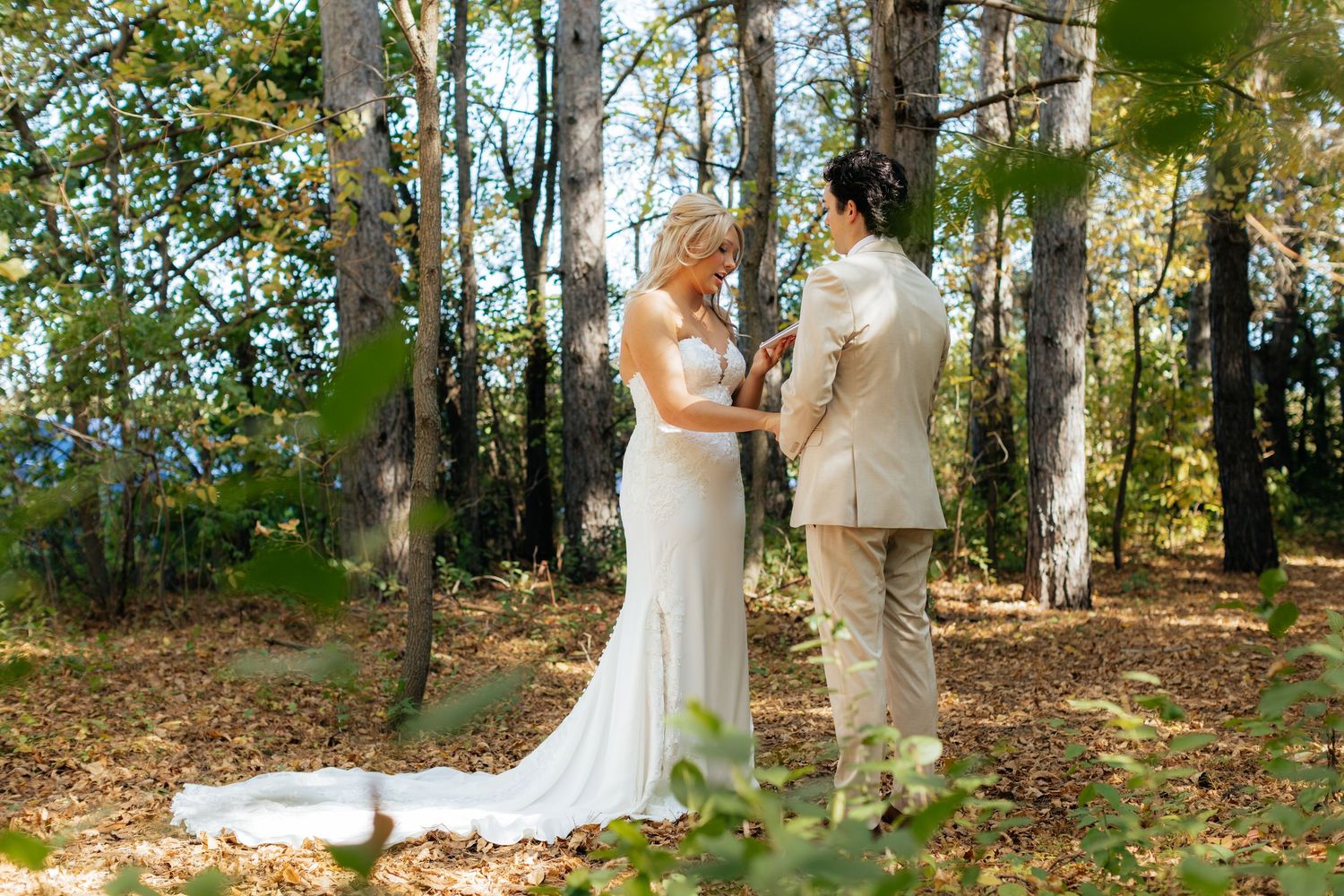 Wedding couple's first look photos captured in a scenic wooded setting with natural lighting.