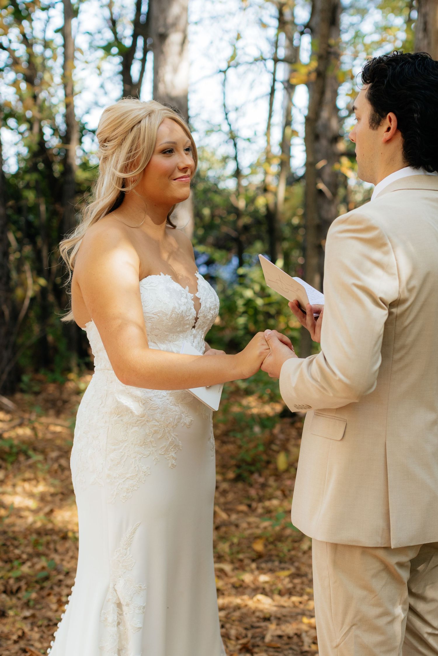 Couple sharing emotional first look moment in autumn forest setting.