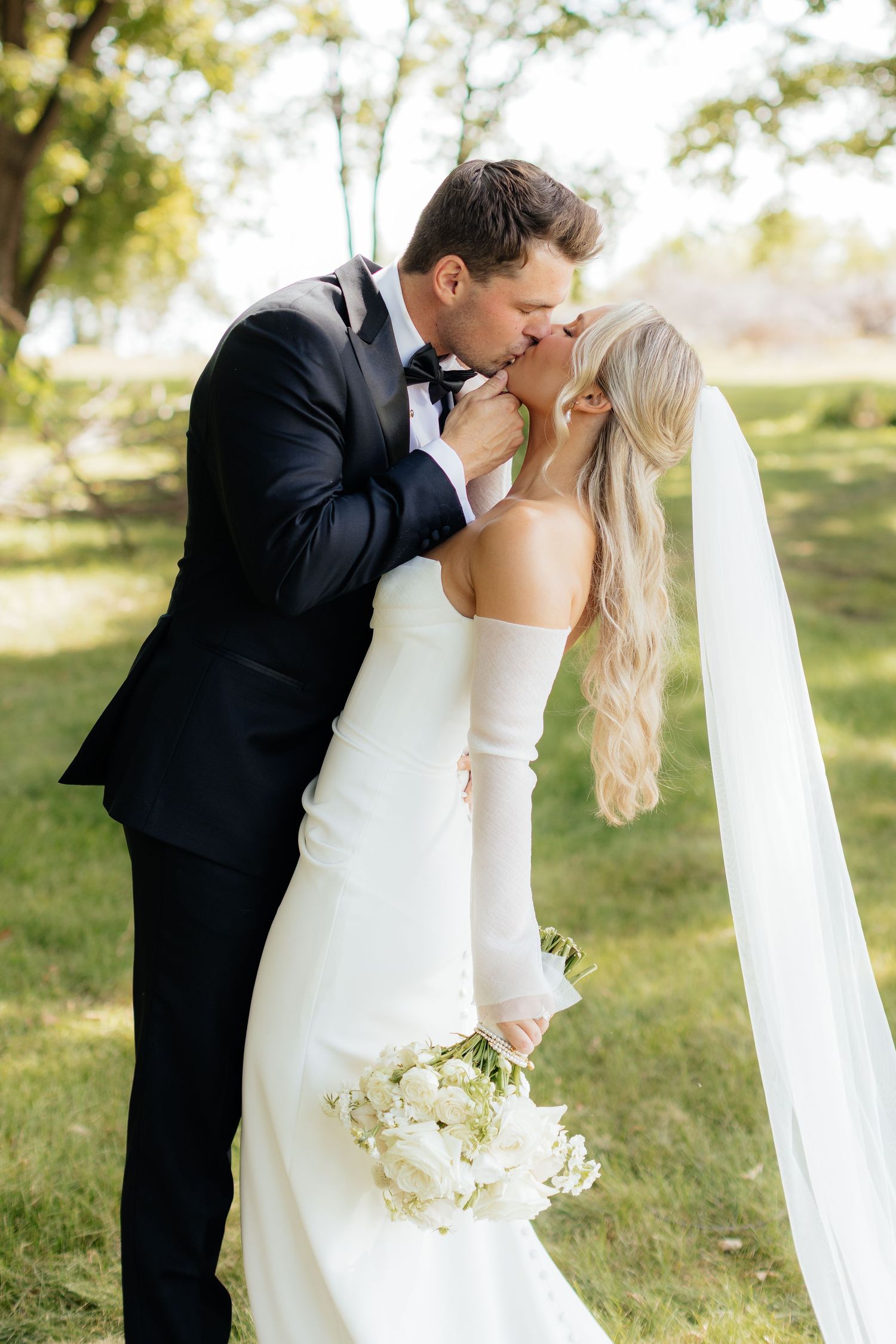 Romantic wedding portraits in natural sunlight with flowing white dress and bouquet.
