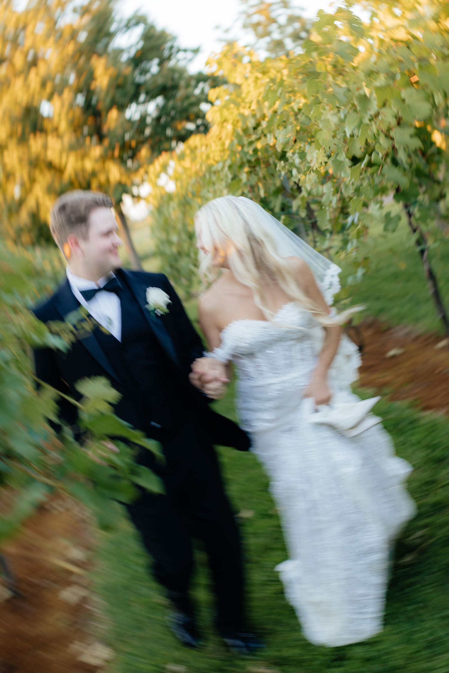 Creative spinning motion wedding photos capture playful moments in vineyard setting.