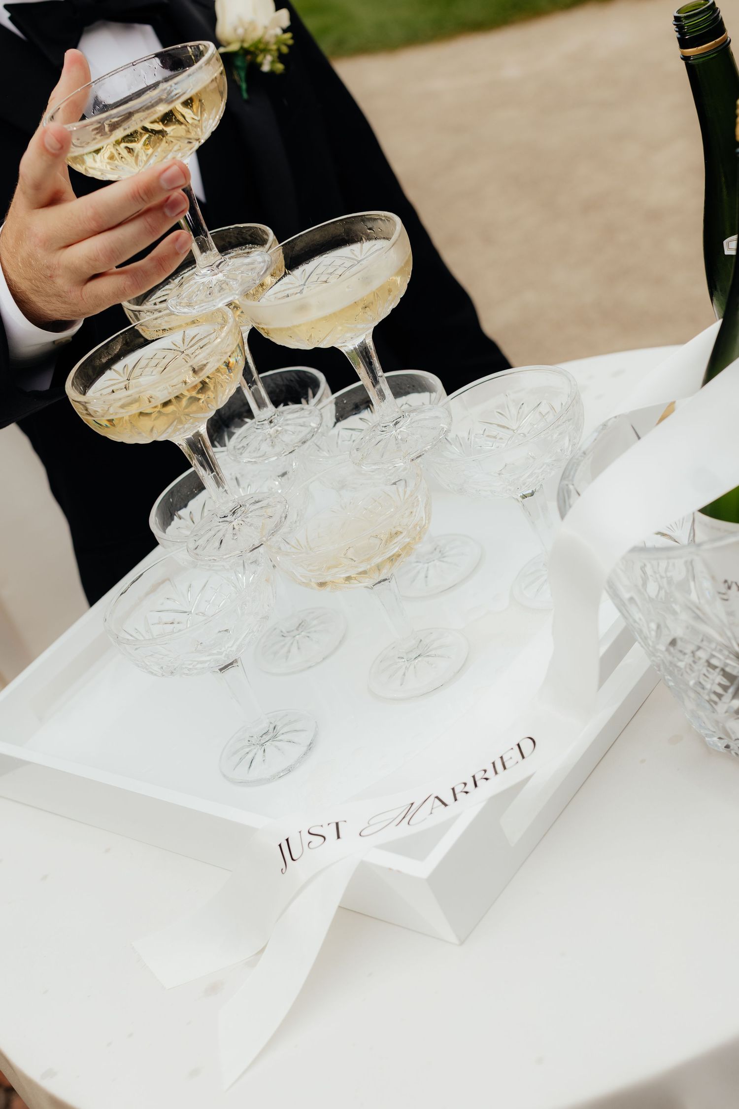 Vintage-style coupe champagne glasses arranged with name cards at a wedding reception.