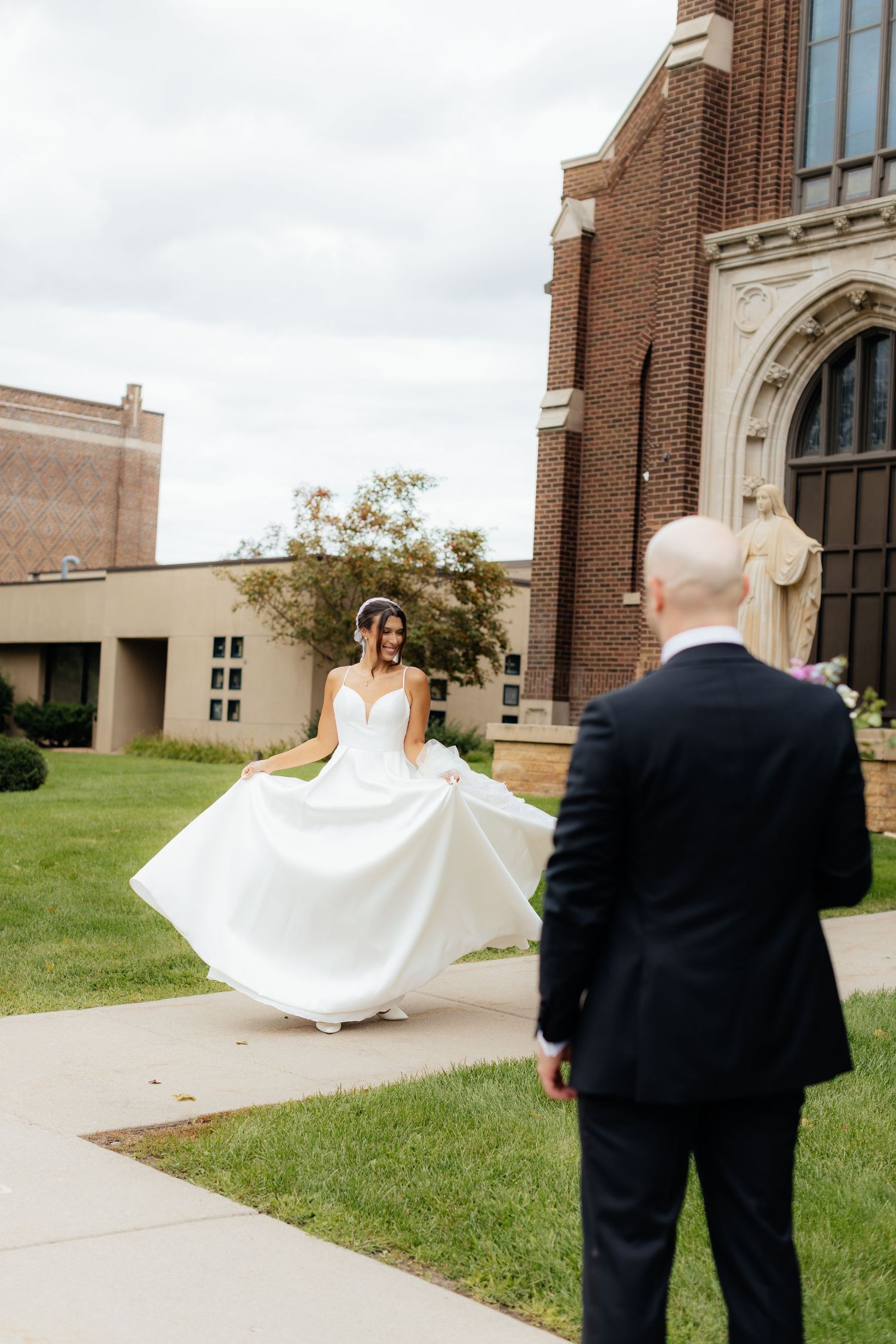 Wedding couple walking along a church sidewalk on their special day.