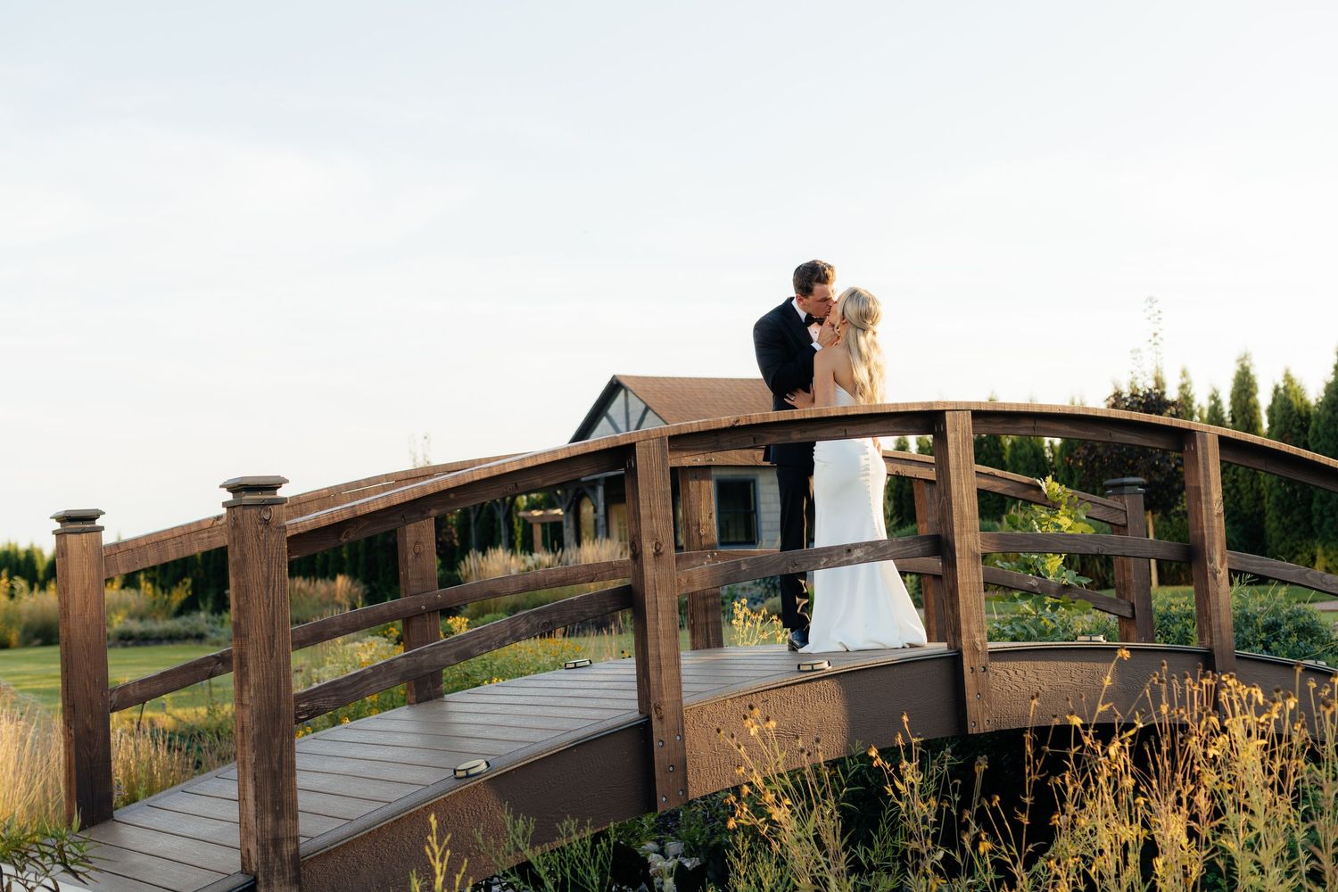 Wooden boardwalk bridge stretches across a scenic landscape during golden hour.