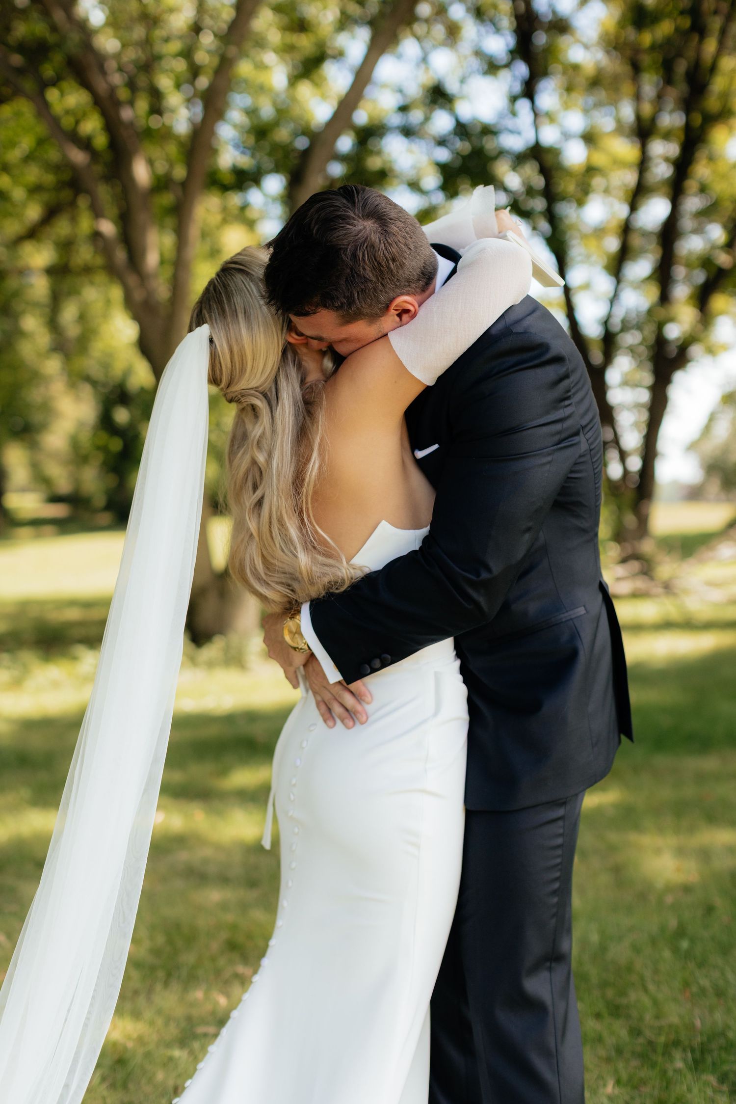 Romantic wedding couple embraces during their outdoor photo session.
