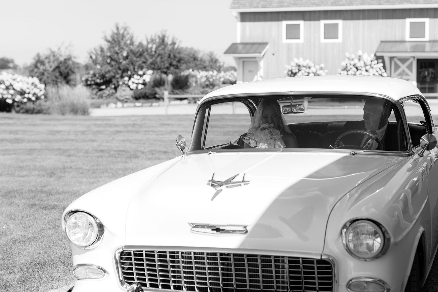 Front view of classic white Chevrolet car at outdoor wedding venue.