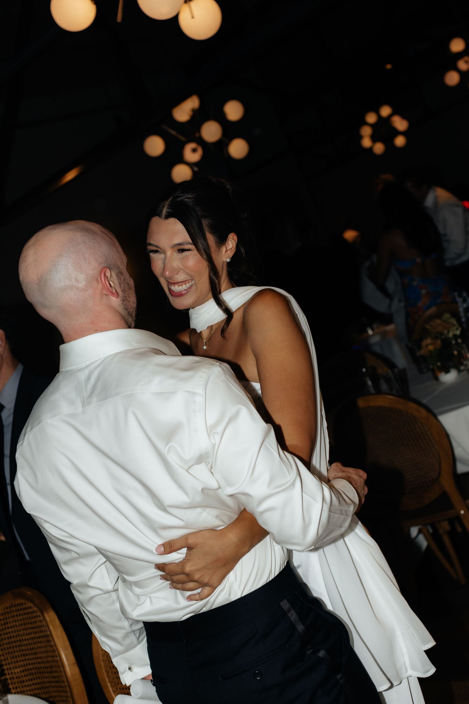 A joyful dance moment captured during an evening celebration with warm lighting.