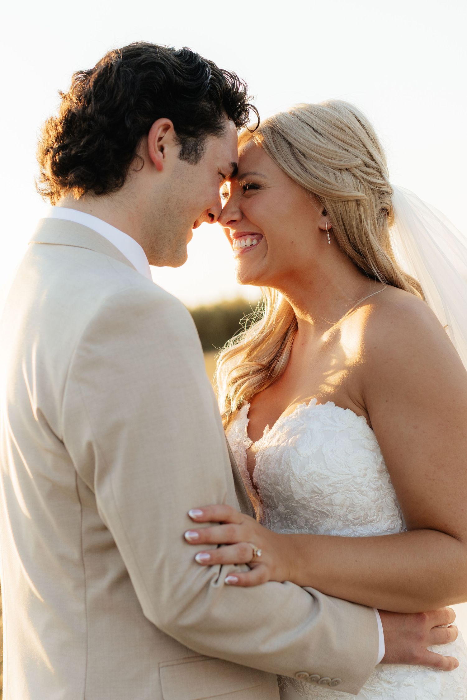 Intimate wedding portraits showing tender moments between newlyweds in warm sunlight.
