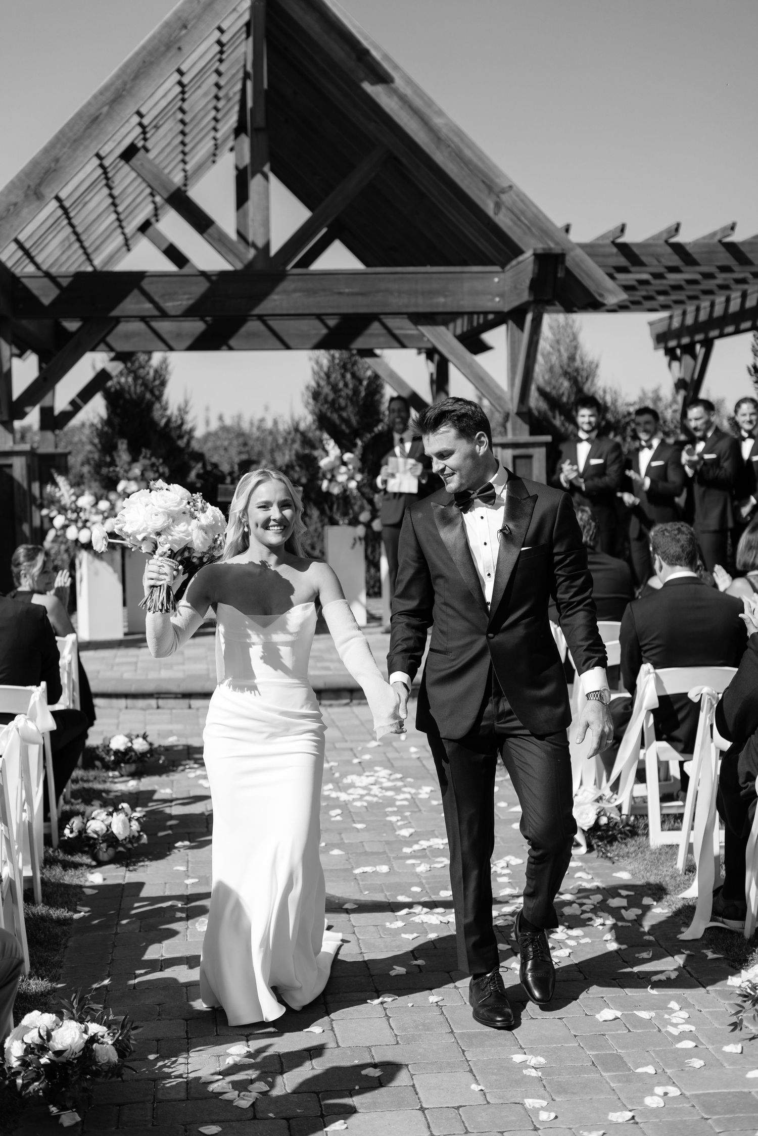 Black and white photo of wedding couple walking down aisle after ceremony.
