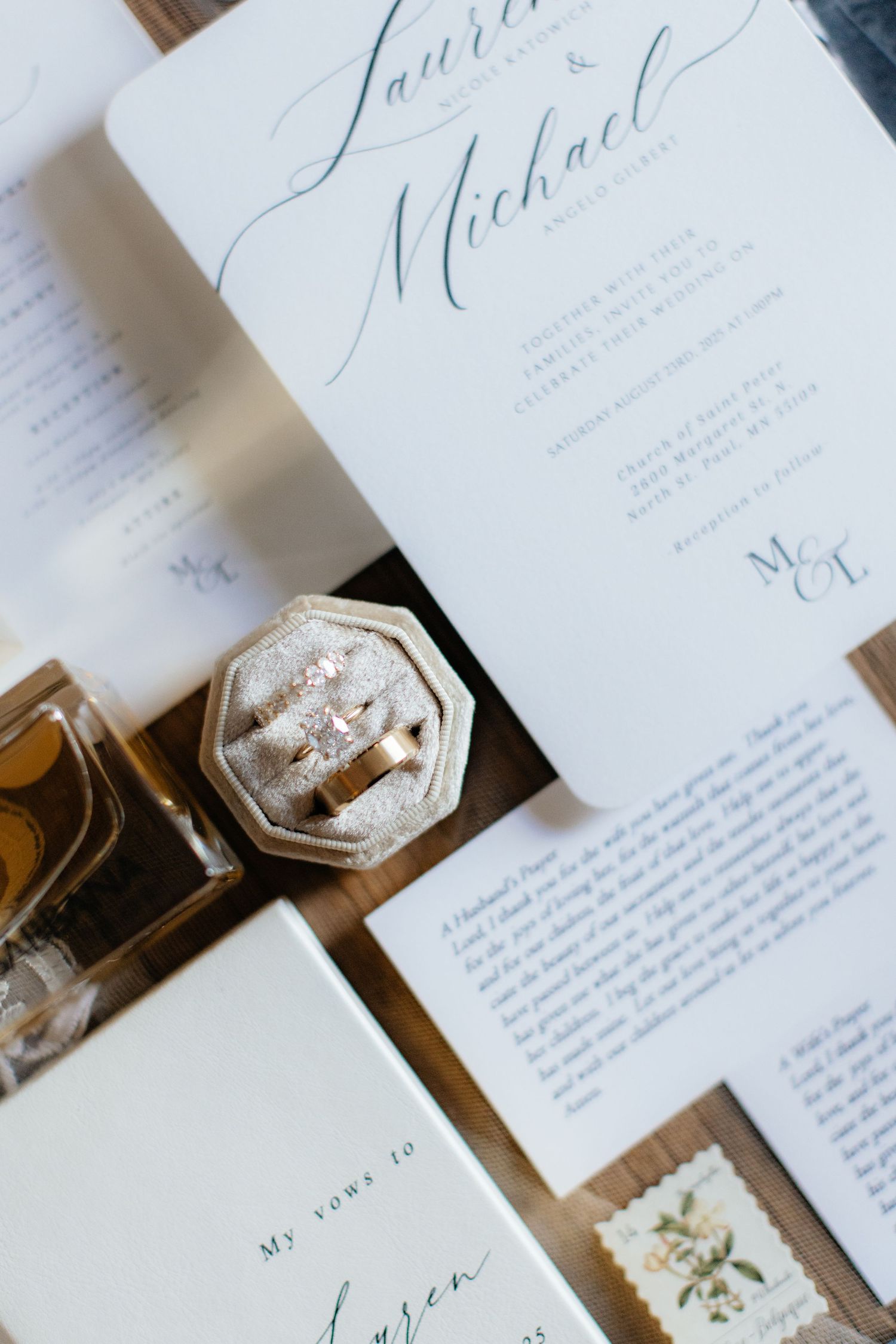 Elegant wedding invitation suite with calligraphy and delicate details on wooden surface.